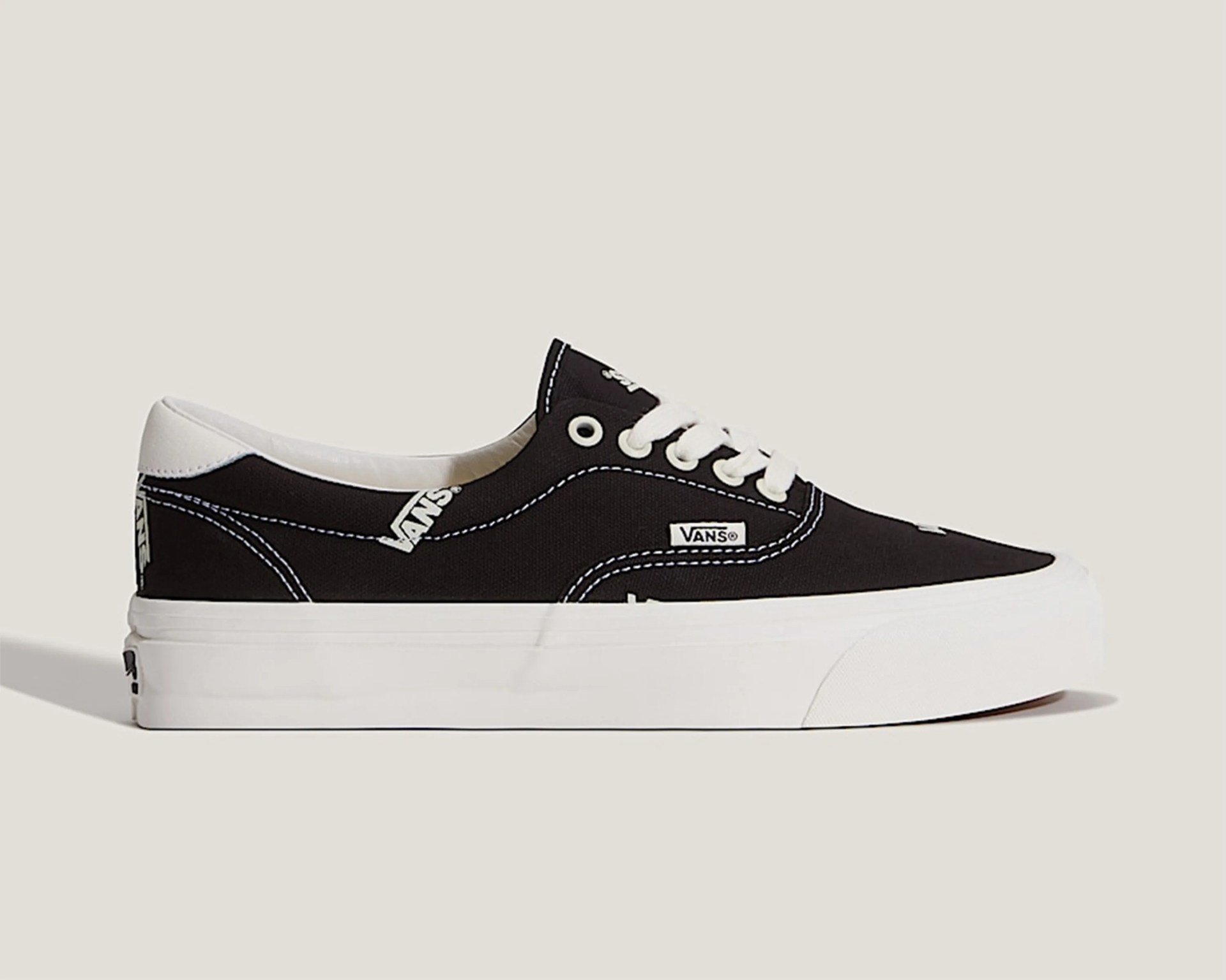 Black Vans low-top sneaker with white laces, white sole, and visible Vans logo patches.
