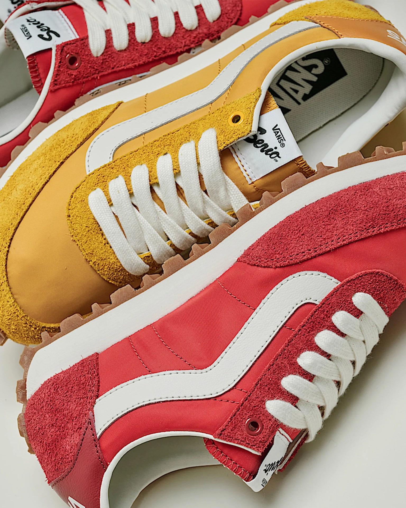 Pair of Vans sneakers with one shoe in yellow and white and the other in red and white, both with white laces and gum soles.