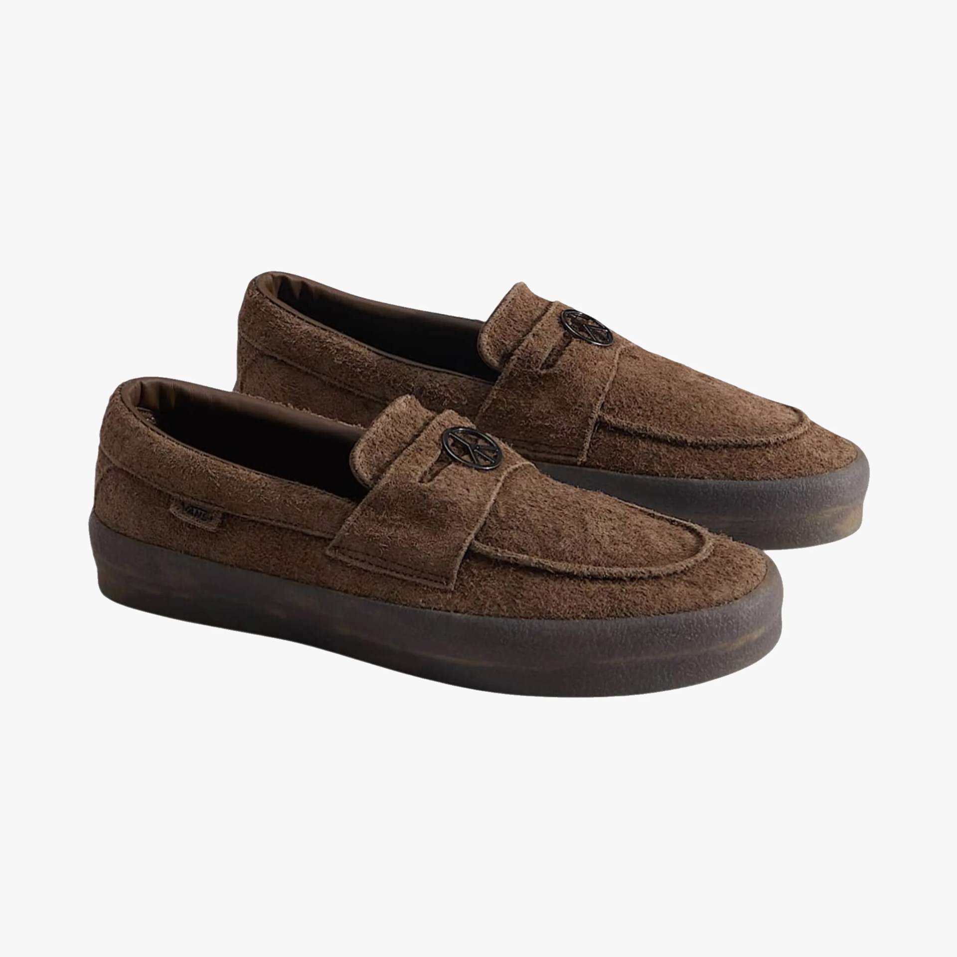 Pair of brown suede loafers with black rubber soles and round metal logo on the strap.