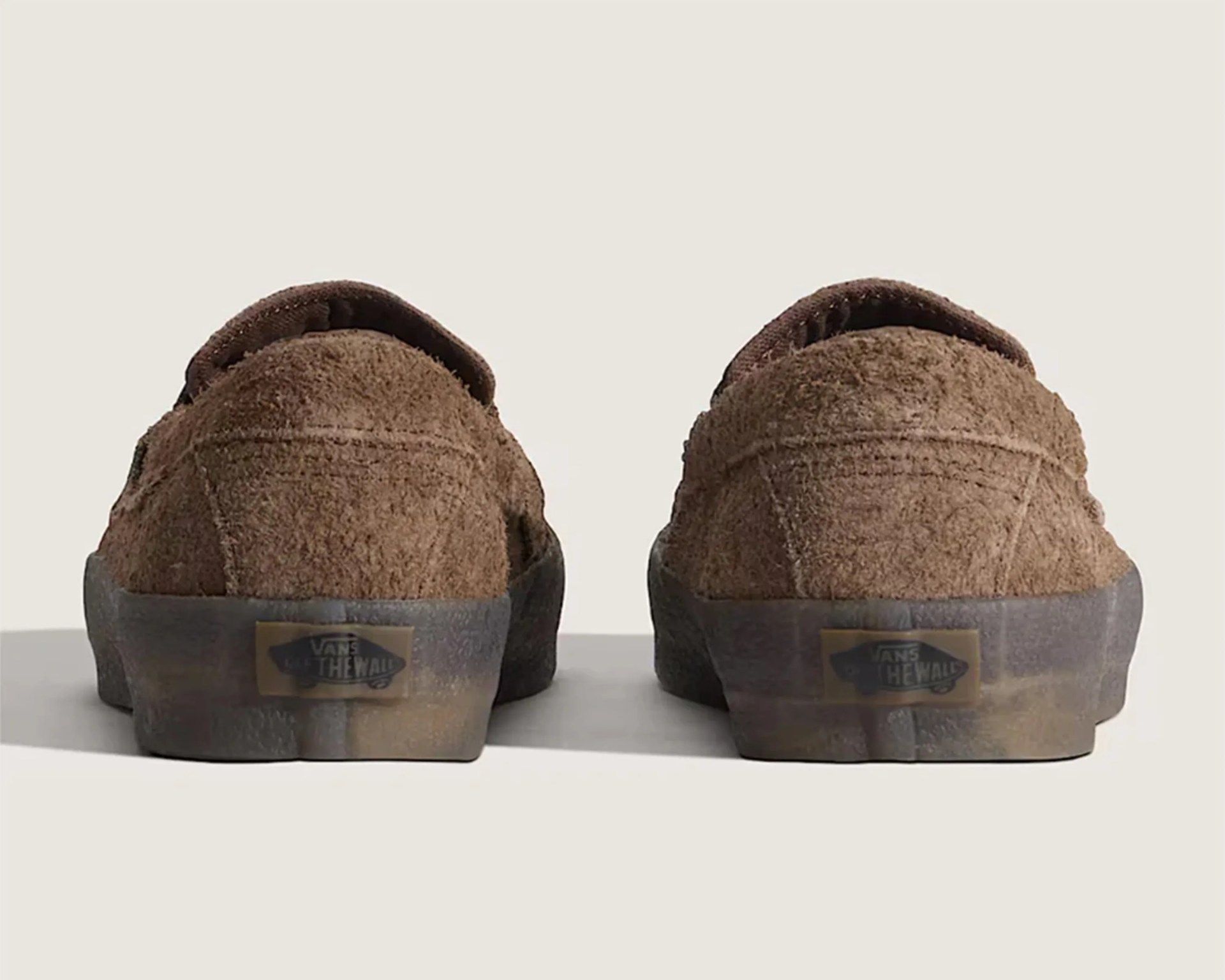 Pair of brown suede Vans shoes shown from the back with black rubber soles and "Vans Off The Wall" logo.