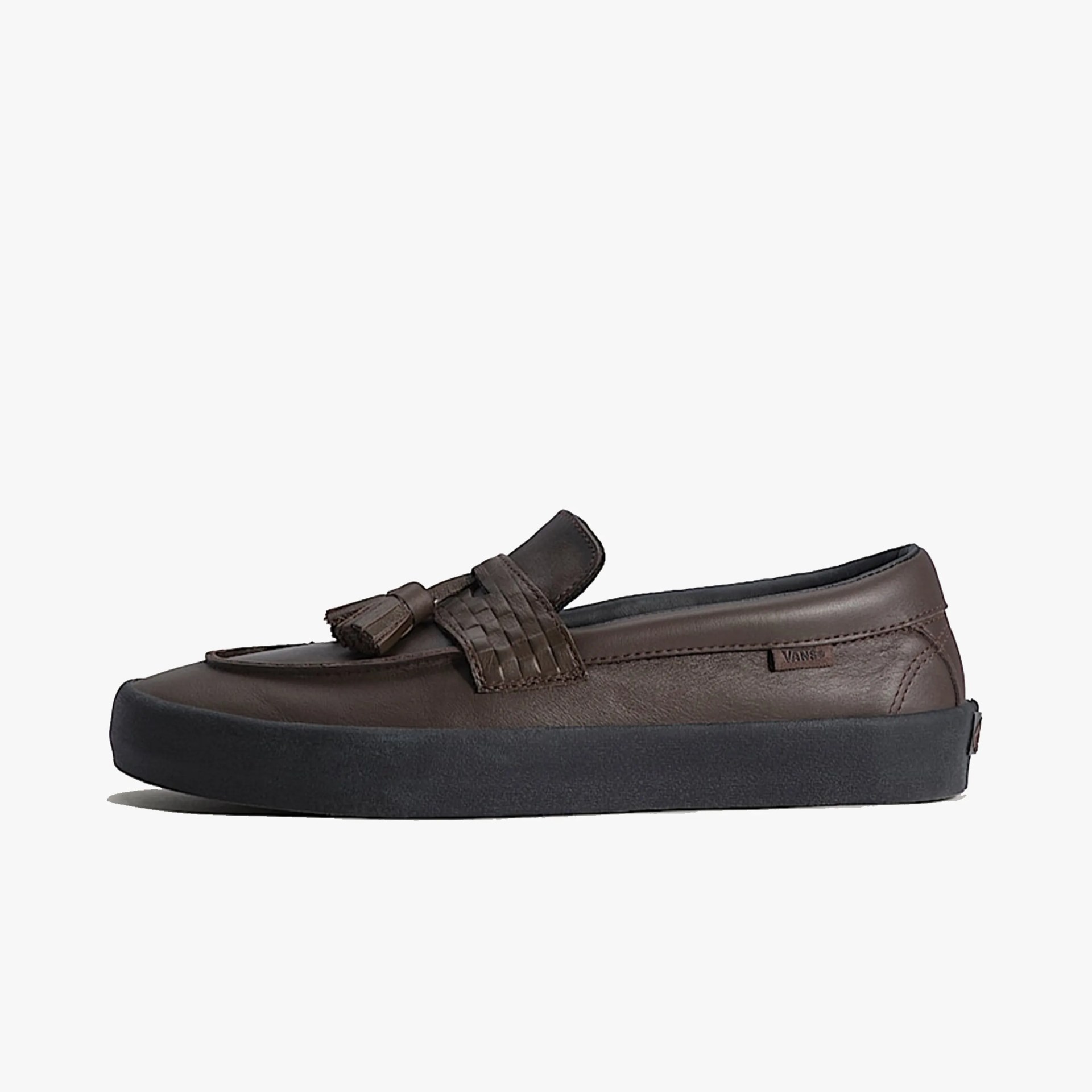 Dark brown leather loafer with woven strap and tassels on a thick black sole.