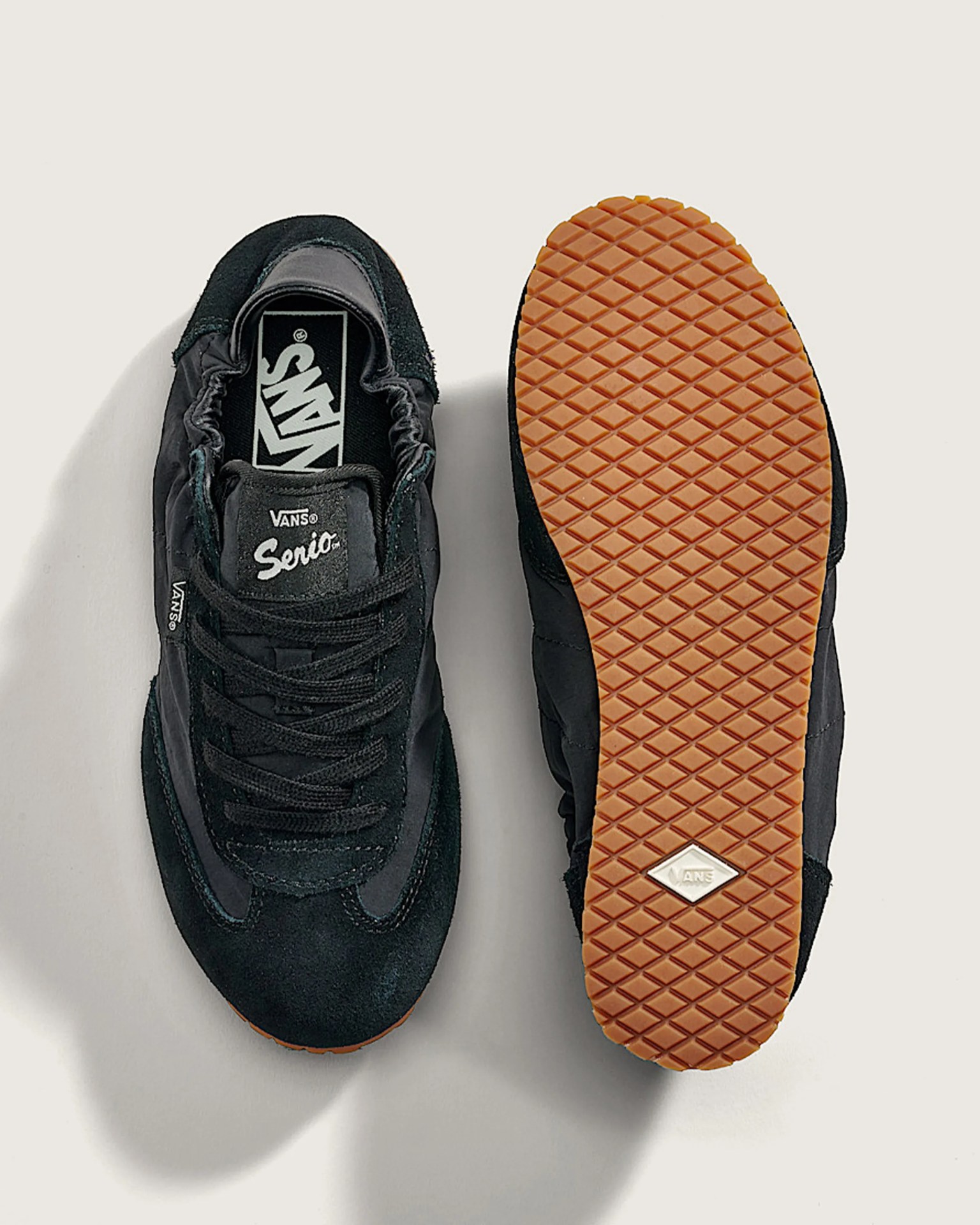 Pair of black Vans Serio sneakers with gum rubber waffle soles, one showing top and the other sole.