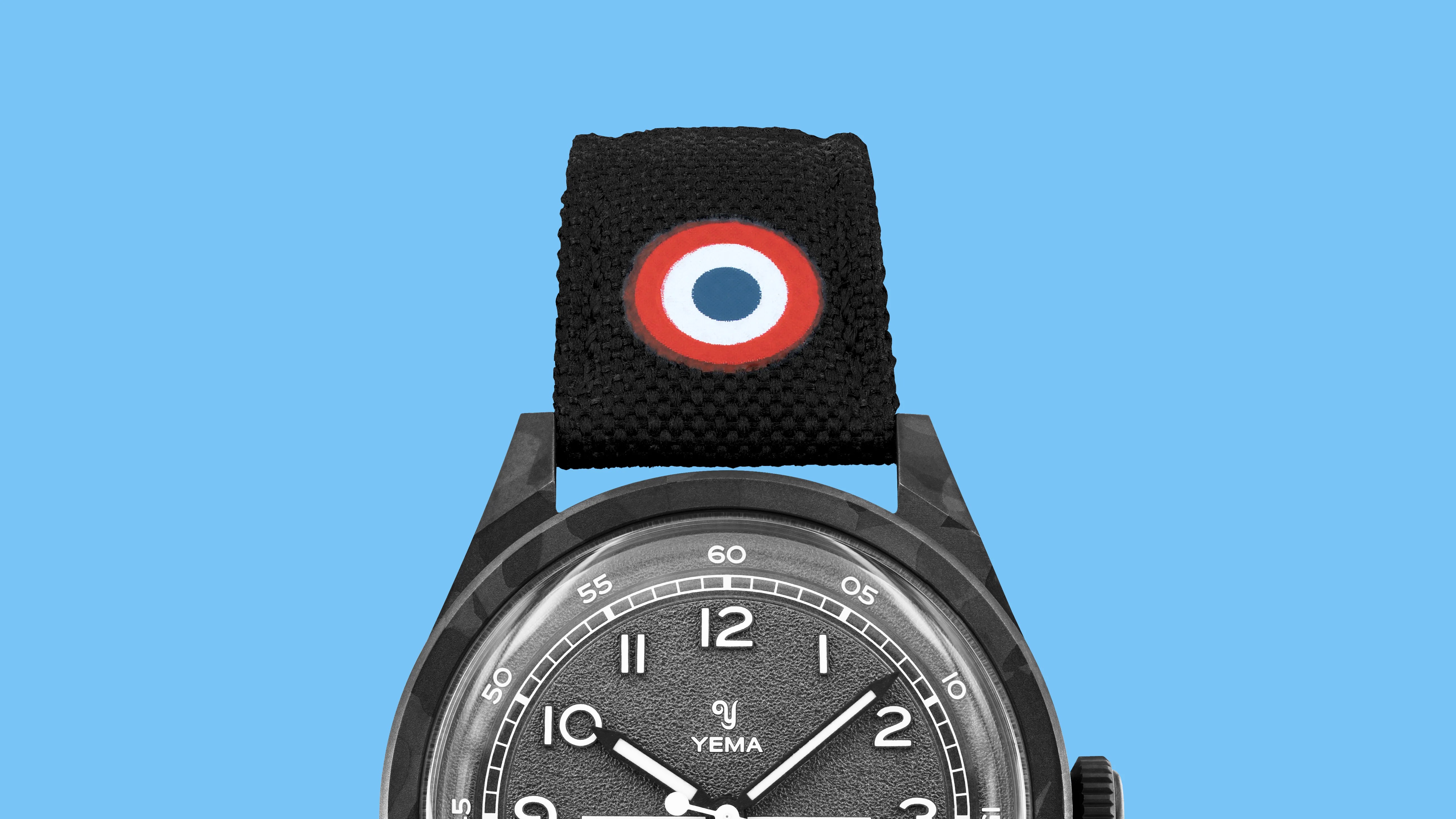Black textured watch strap with a red, white, and blue roundel emblem above a black Yema watch face.