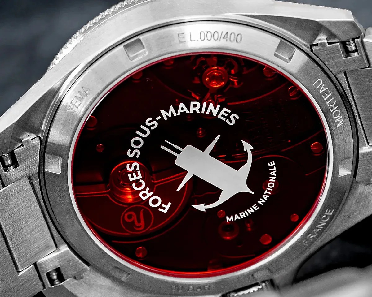 Close-up of a stainless steel watch back with a red transparent cover displaying "Forces Sous-Marines Marine Nationale" and an anchor-submarine logo.