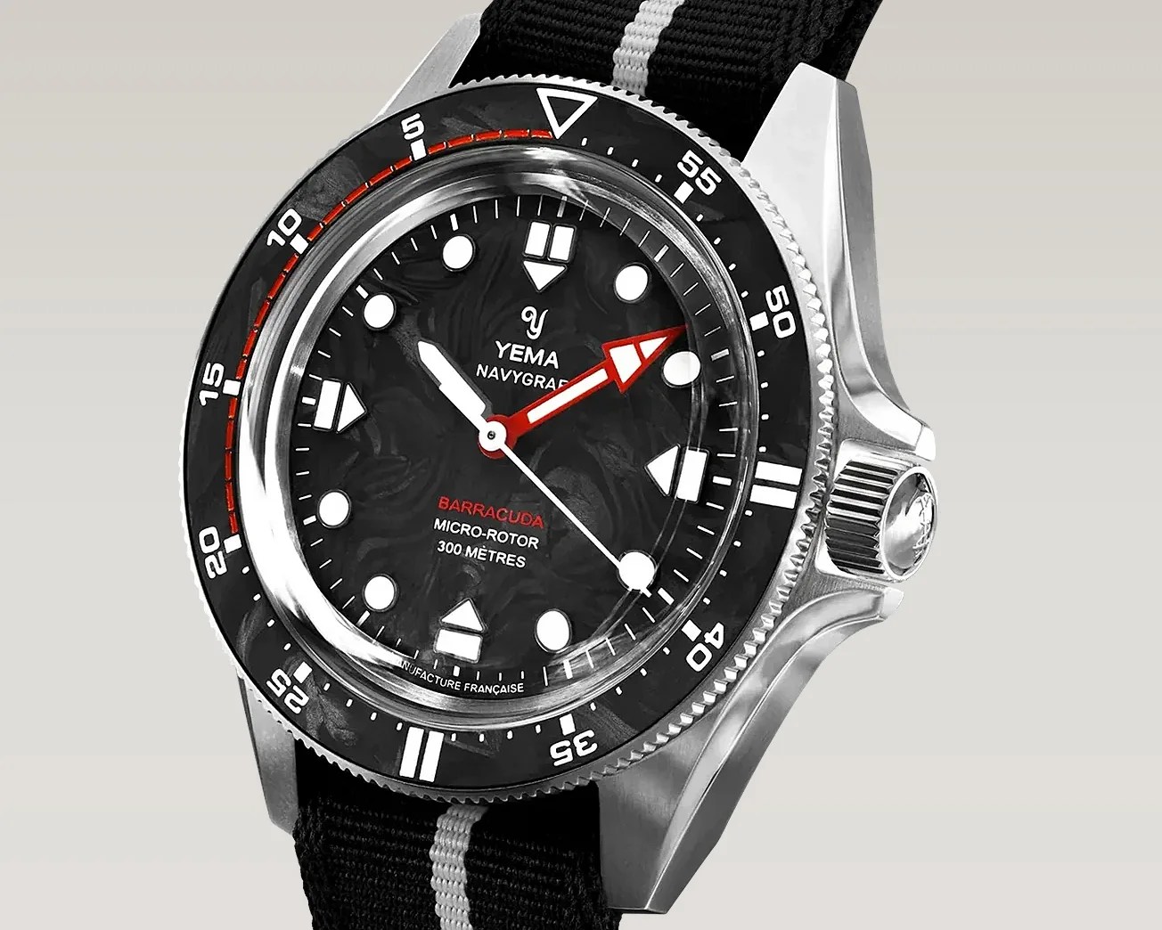 Stainless steel Yema Navygraf Barracuda dive watch with black textured dial, red and white hands, and black fabric strap.