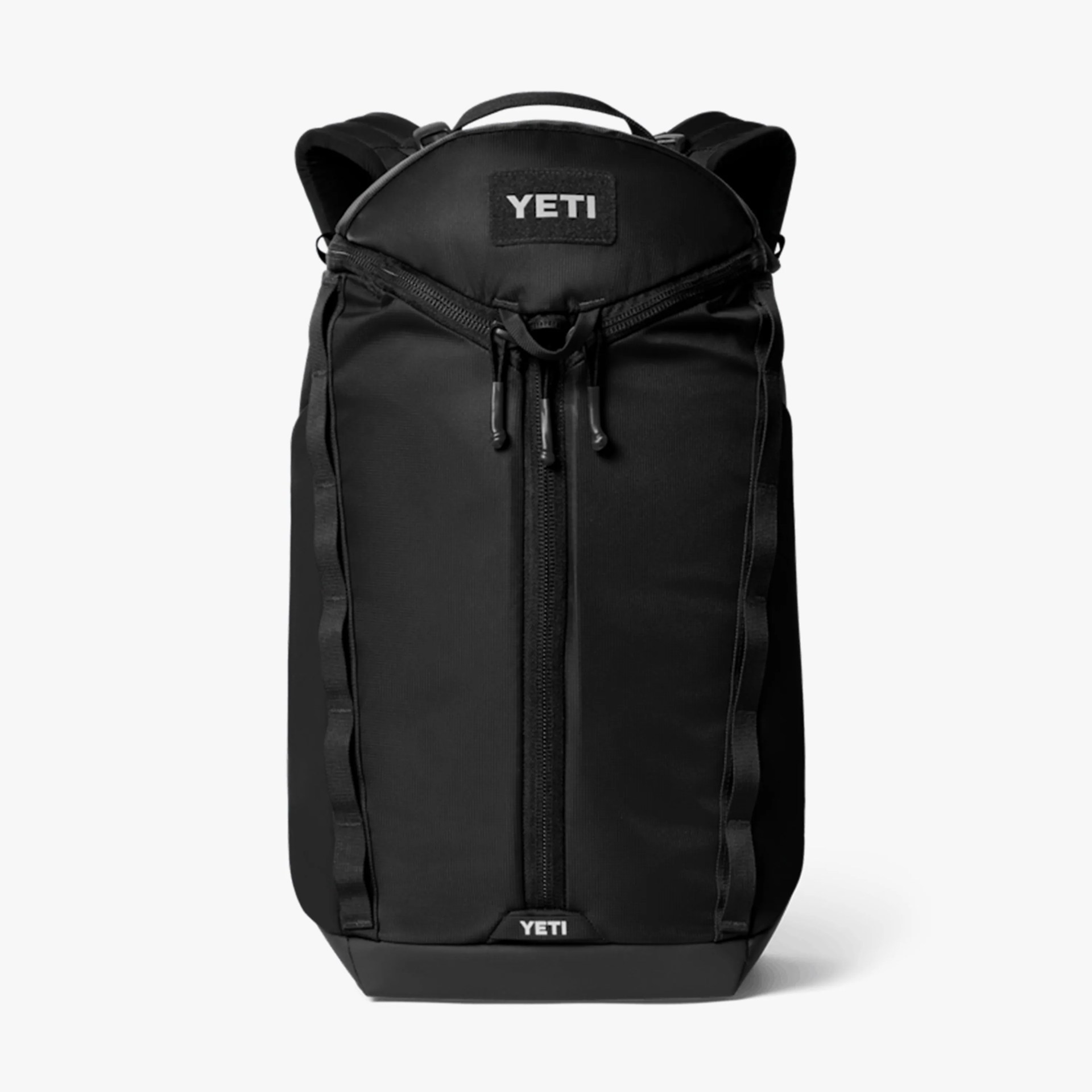 Black YETI backpack with vertical zipper and padded shoulder straps on a white background.
