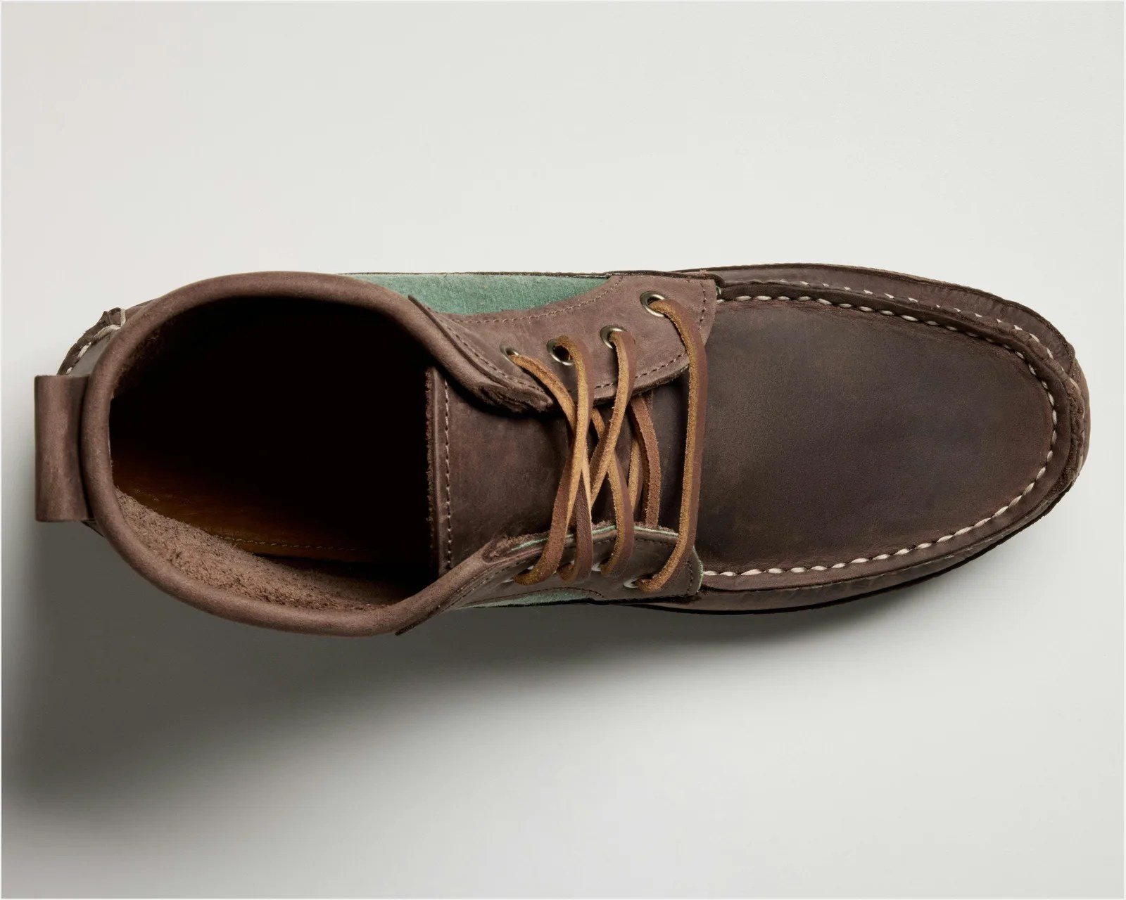 Top view of a brown leather lace-up boot with visible stitching and green fabric side panels.
