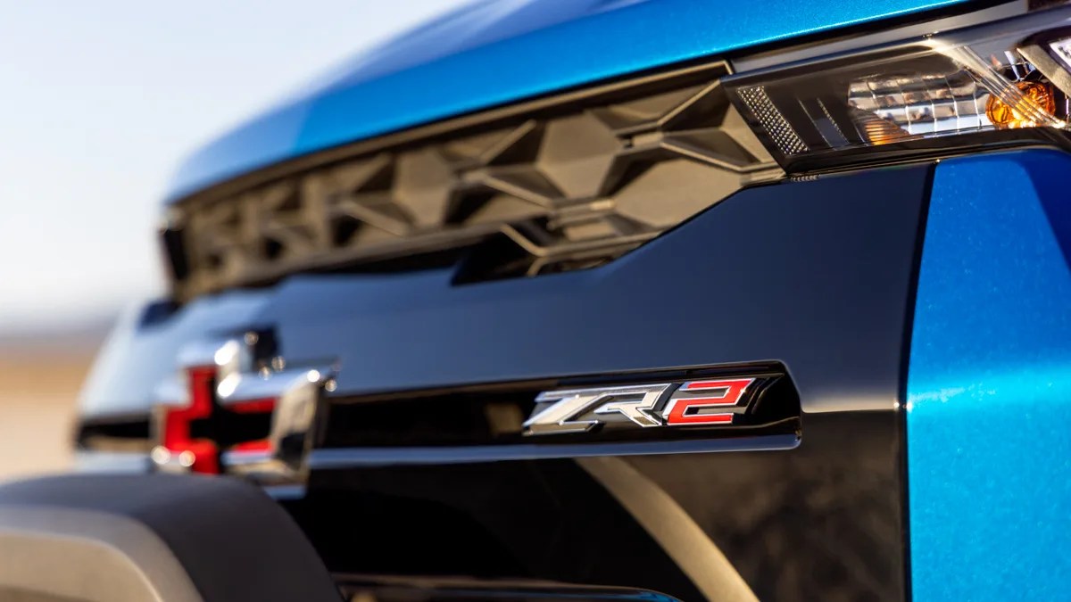 Close-up of a blue vehicle's front grille with a black and red Chevrolet emblem and a "ZR2" badge.