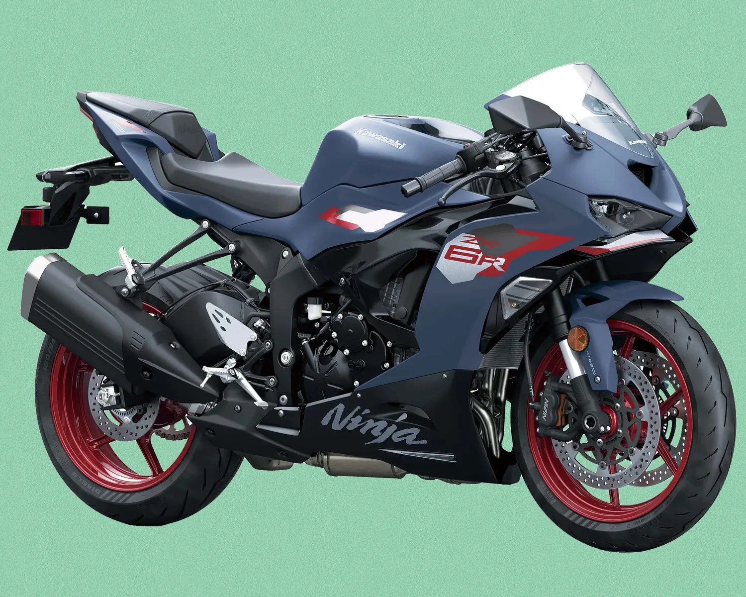 Matte blue Kawasaki Ninja ZX-6R sport motorcycle with red wheels on a green background.