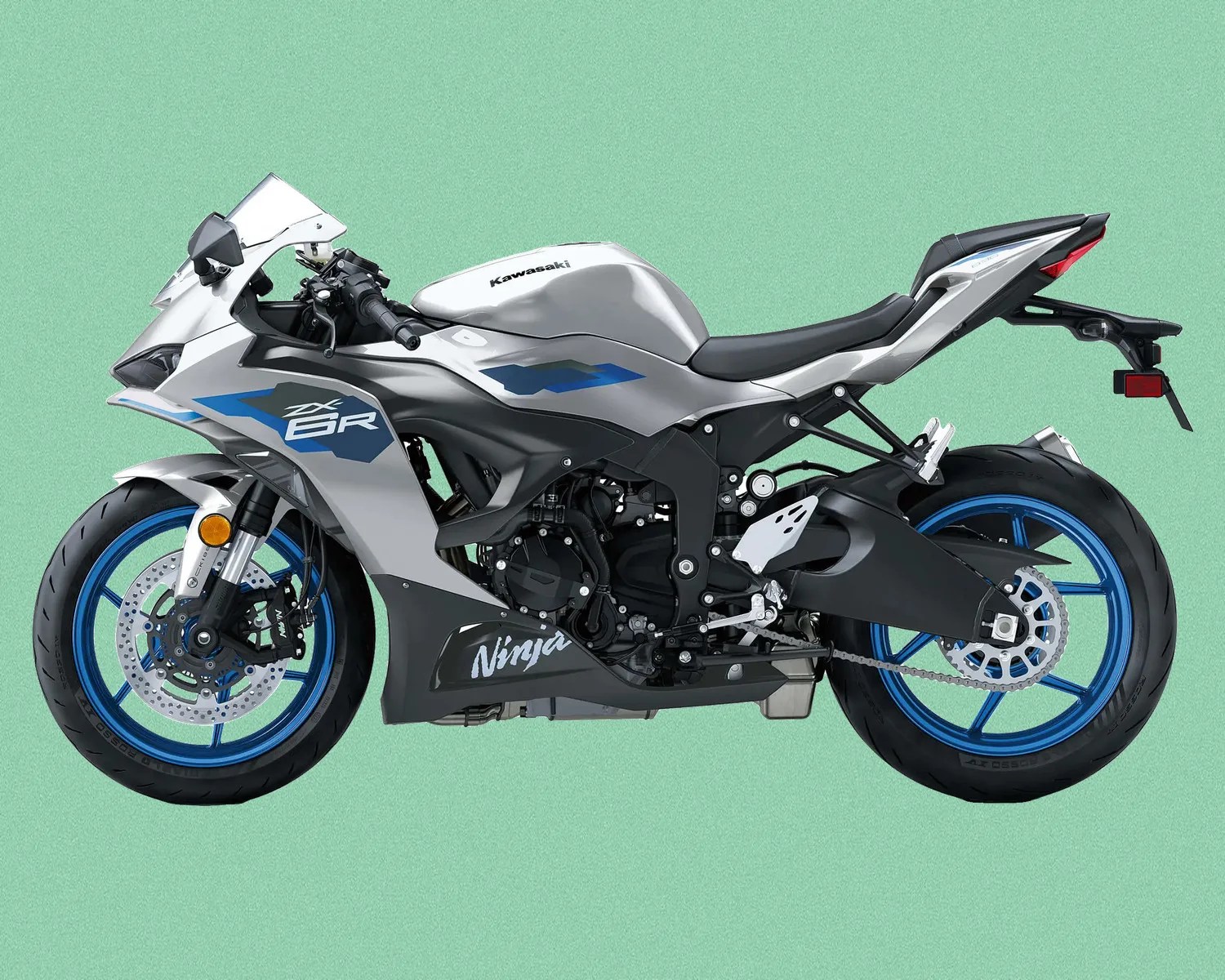 Silver and black Kawasaki Ninja ZX-6R sport motorcycle with blue wheels on a green background.