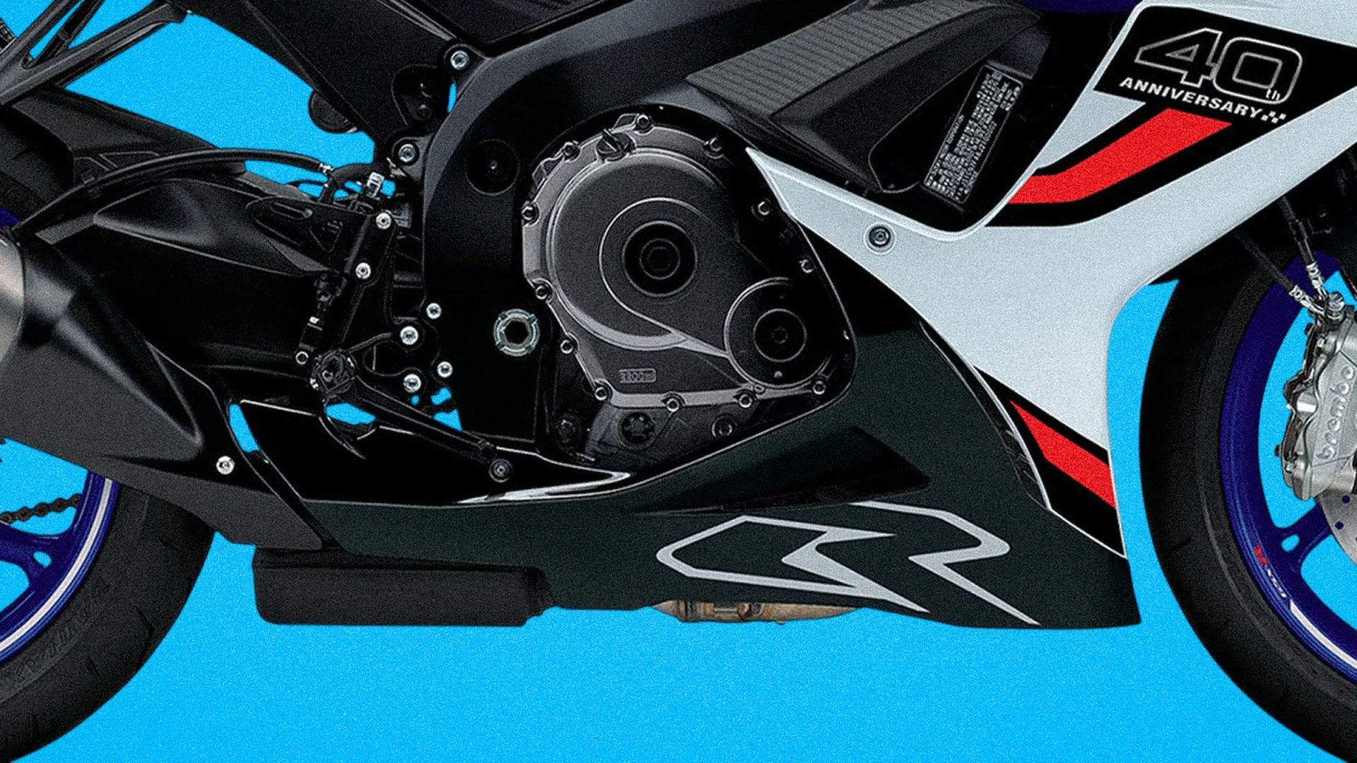Close-up of a black motorcycle engine and lower fairing with "40th Anniversary" decal and blue wheels.
