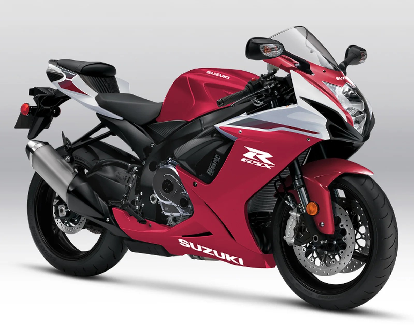 Red and white Suzuki GSX-R sport motorcycle with black seat and silver exhaust on a gray background.