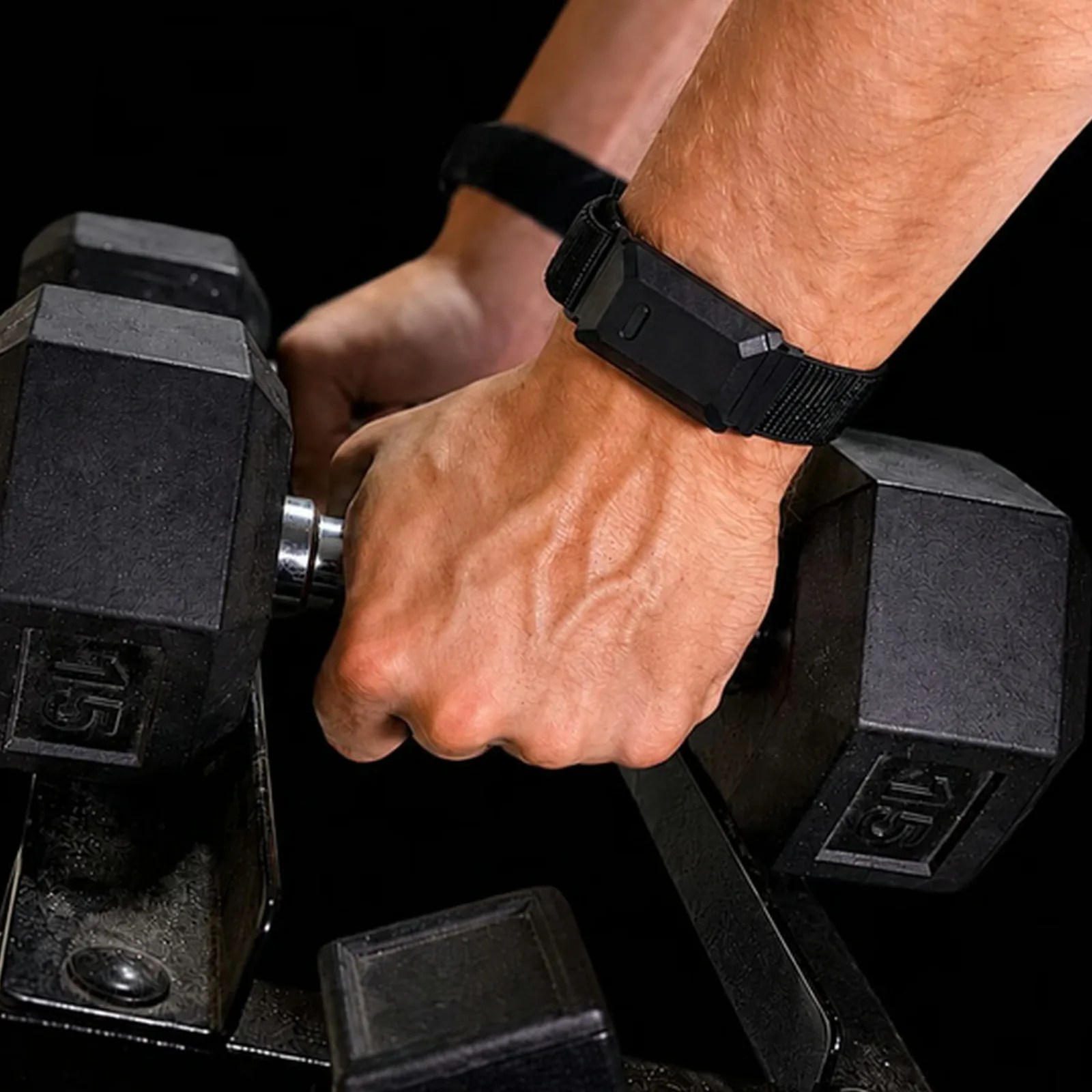 Hand wearing a black fitness tracker wristband gripping a 15-pound hex dumbbell on a rack.