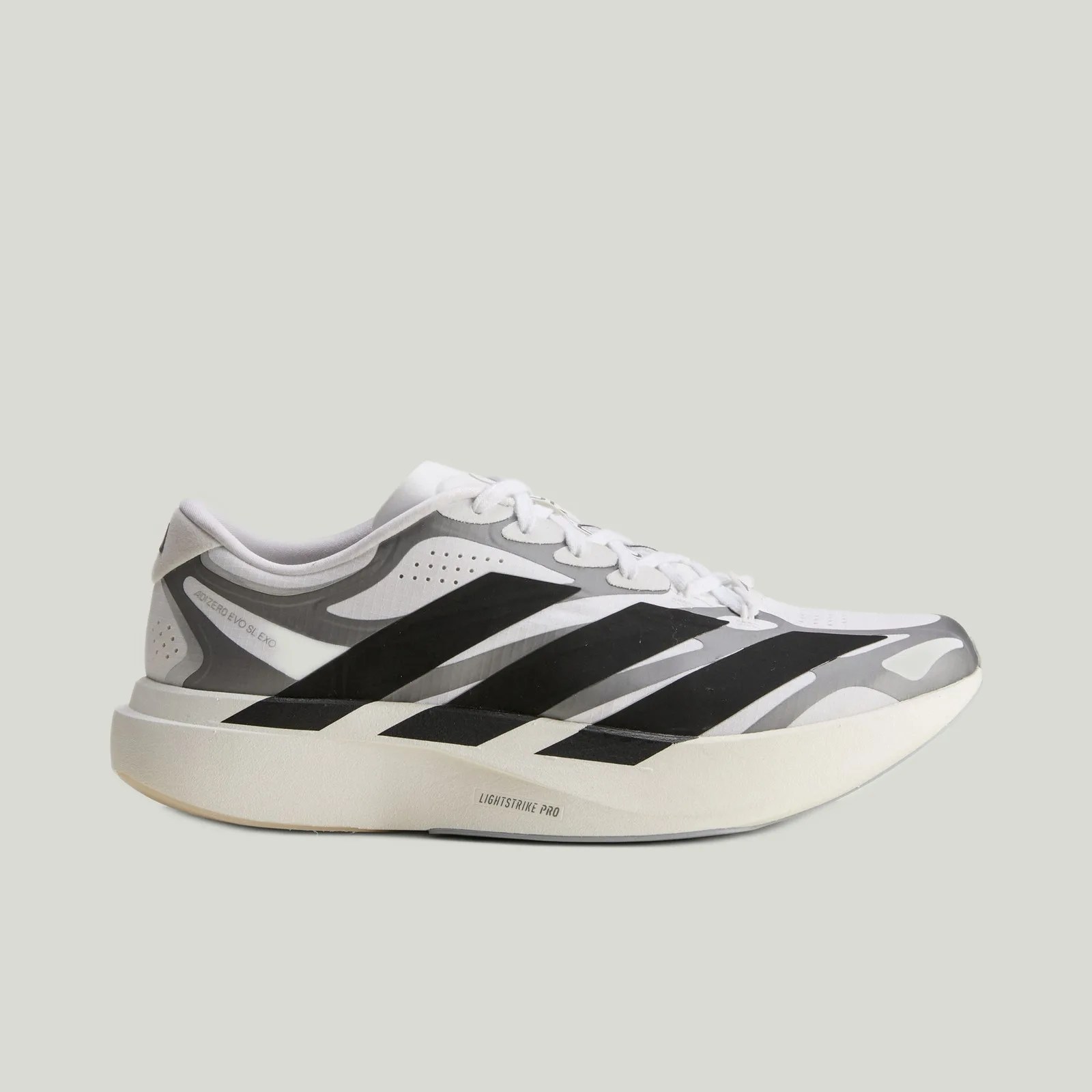 White and gray running shoe with black stripes and thick white sole labeled "Lightstrike Pro.