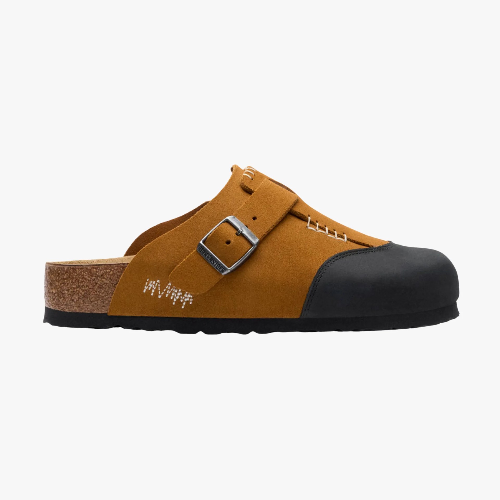 Brown suede slip-on clog with black toe cap, silver buckle, and cork sole.