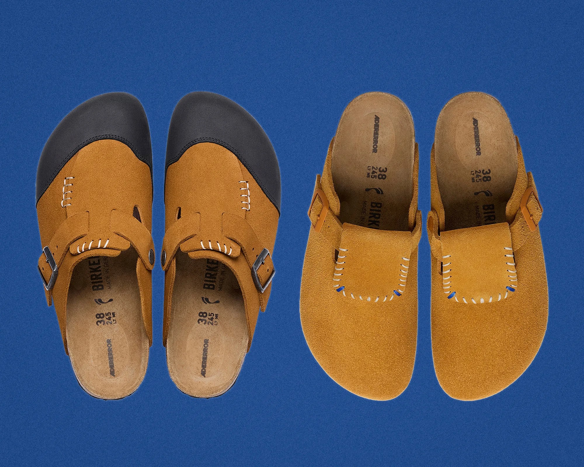 Pair of tan suede Birkenstock clogs with black toe caps on a blue background.