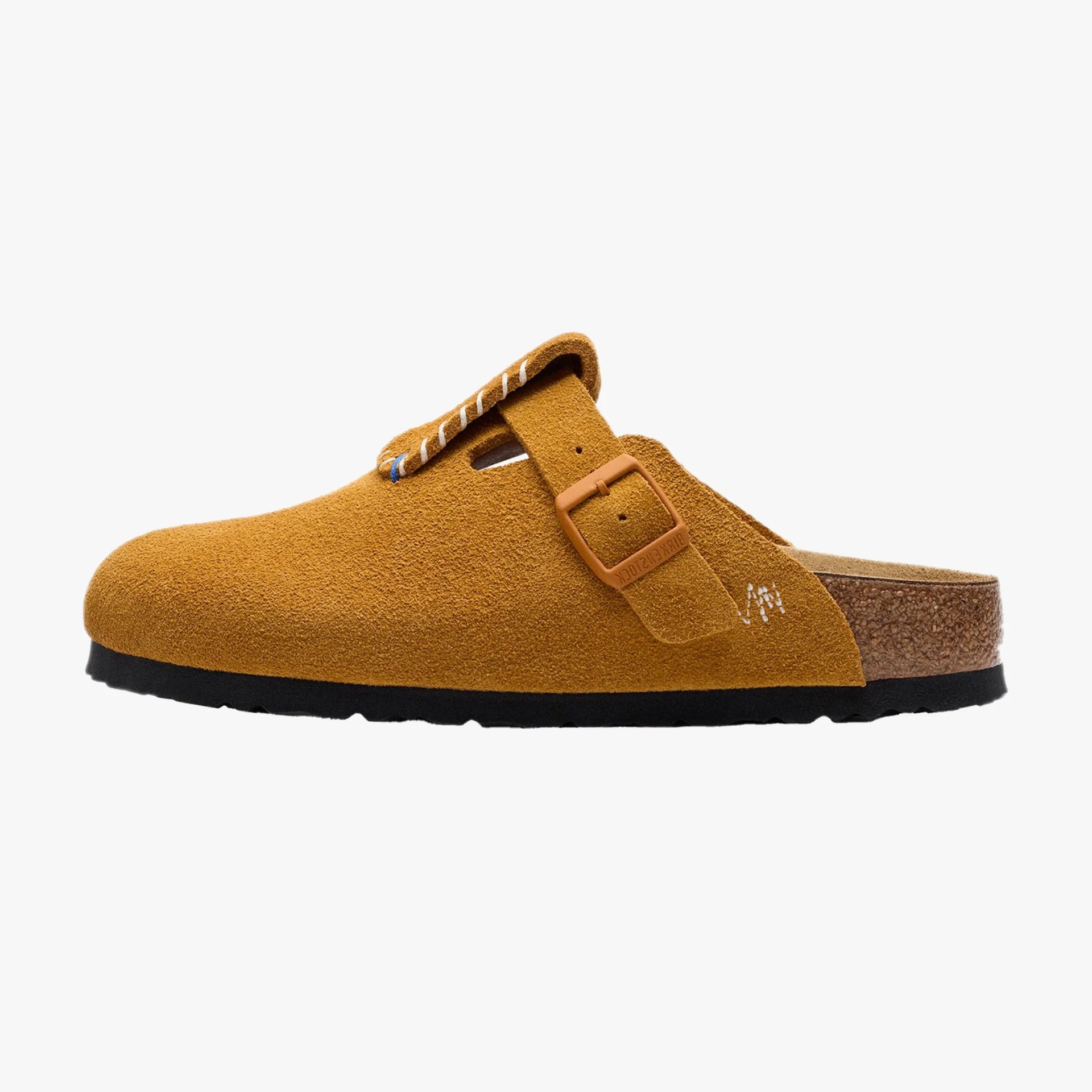 Tan suede slip-on clog with adjustable strap and cork footbed on a white background.