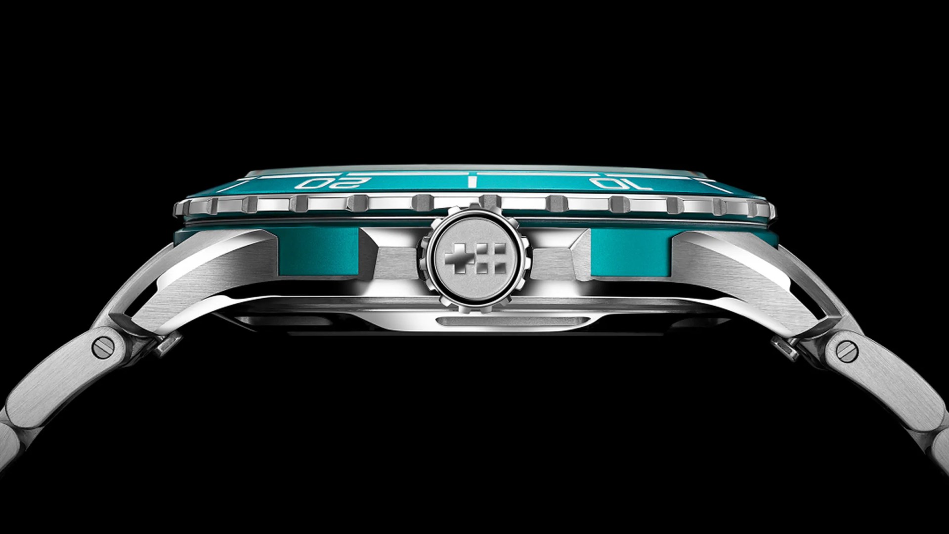 Side view of a silver metal wristwatch with a turquoise bezel and crown featuring a plus and grid symbol.