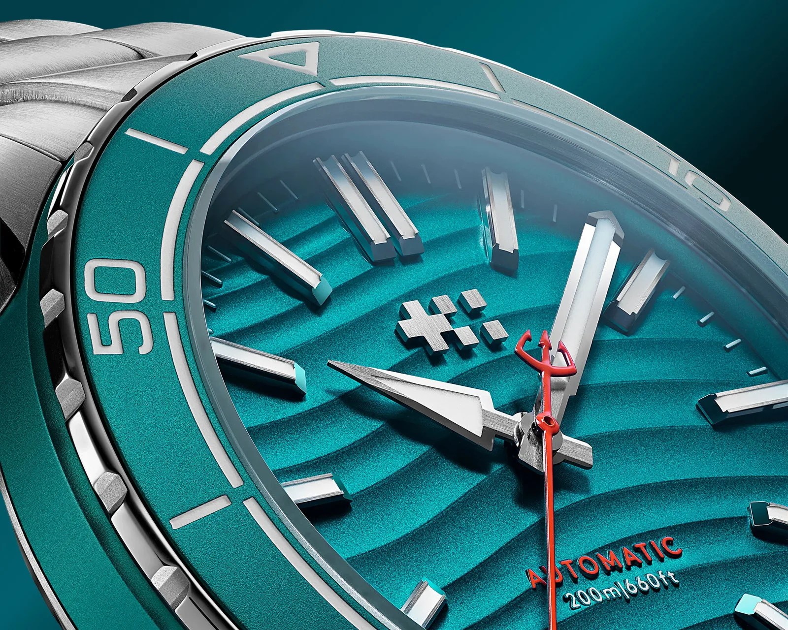 Close-up of a teal automatic dive watch face with silver hour markers, a red second hand, and "200m/660ft" water resistance text.