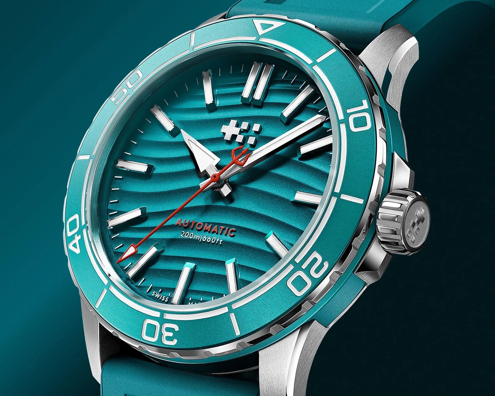 Turquoise automatic dive watch with wave-patterned dial, silver markers, red second hand, and matching rubber strap.