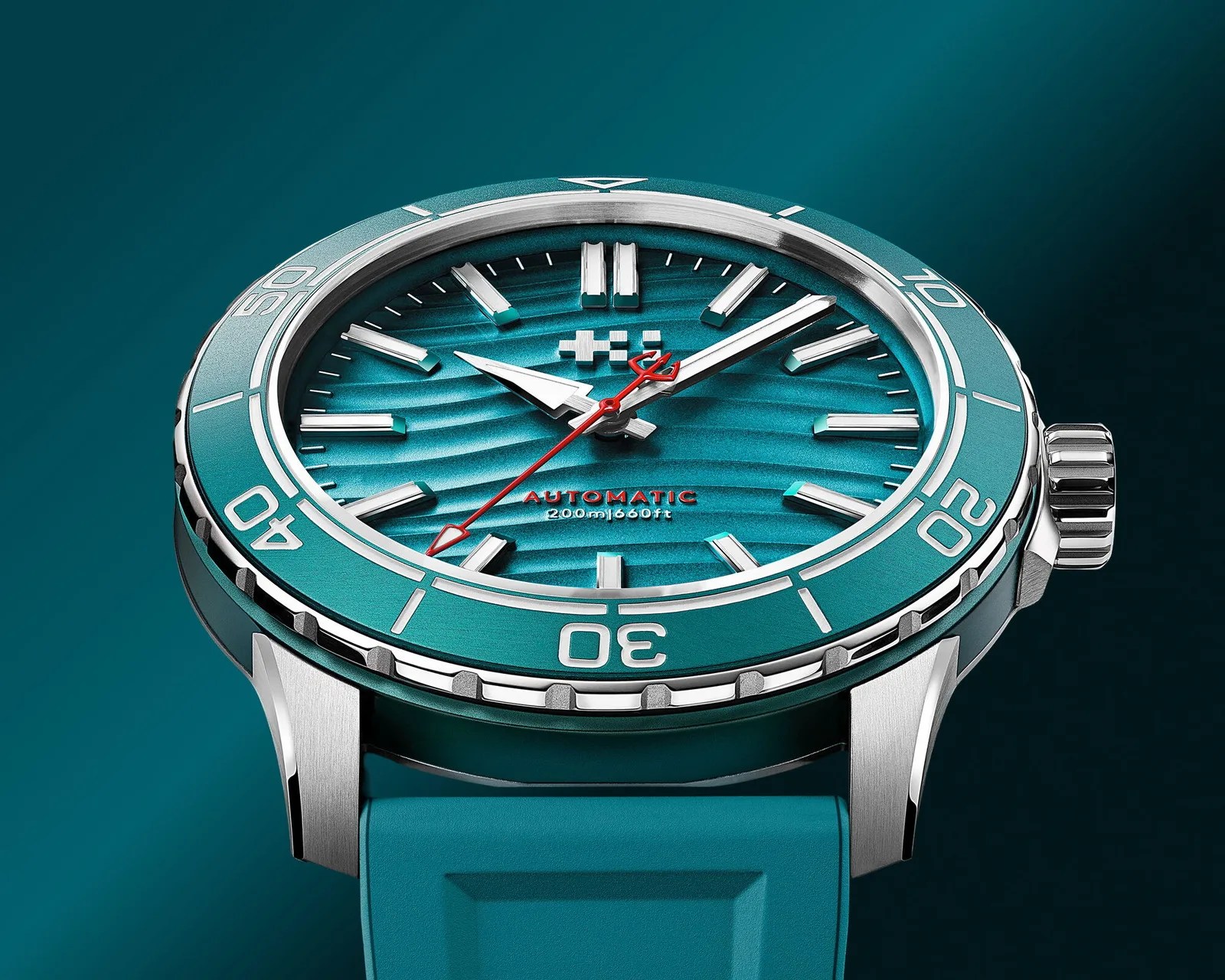 Close-up of a teal automatic dive watch with silver markers, red second hand, and matching teal rubber strap.