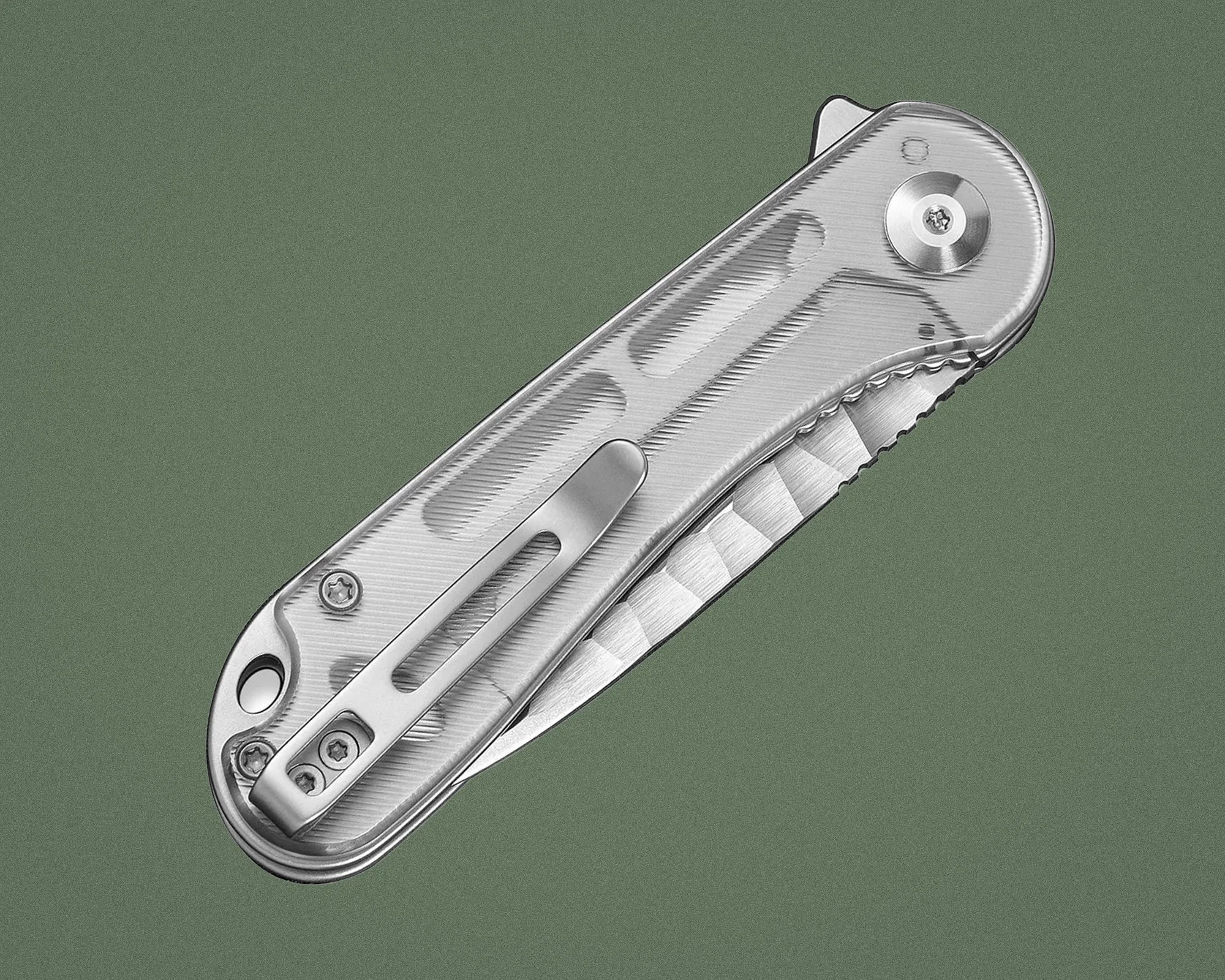 Silver metal folding knife with textured handle and pocket clip on a green background.