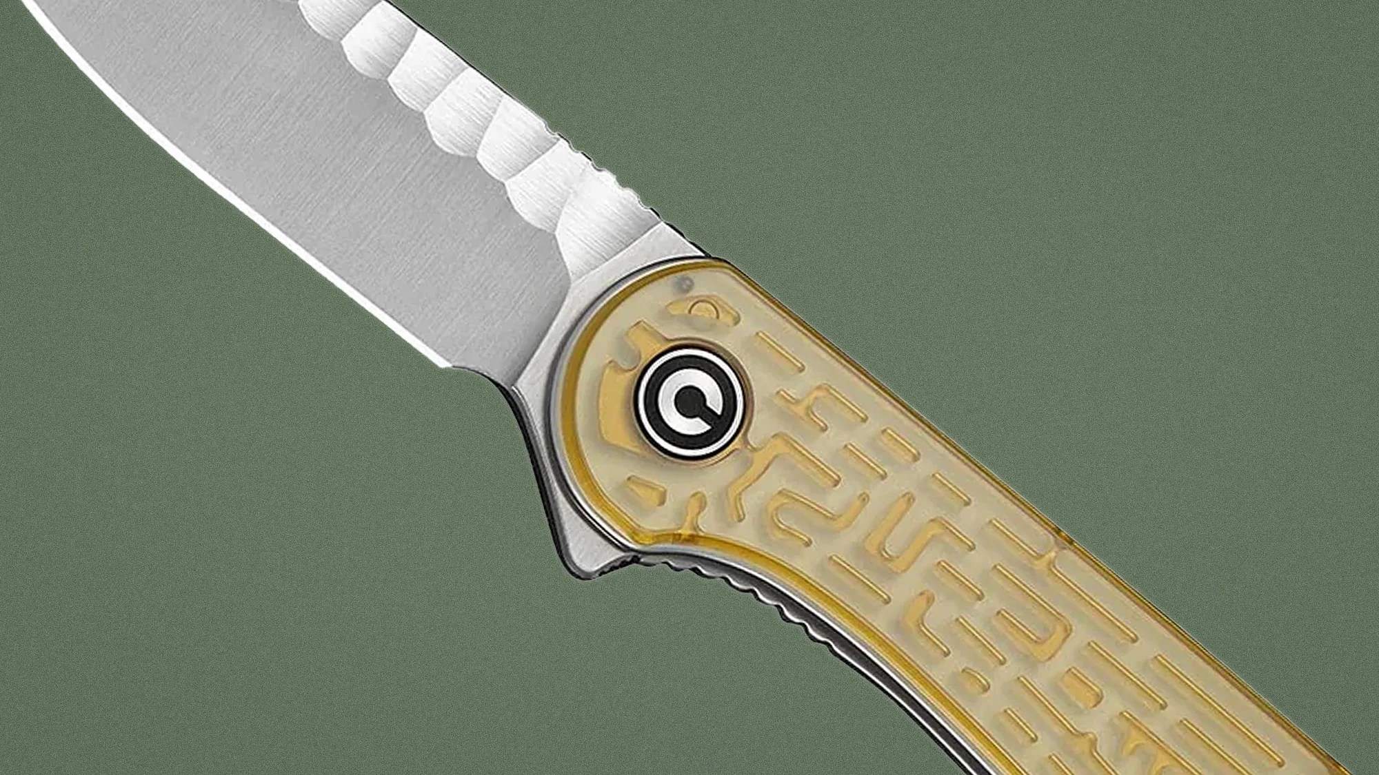Close-up of a folding knife with a partially serrated stainless steel blade and a translucent yellow handle with a maze pattern.