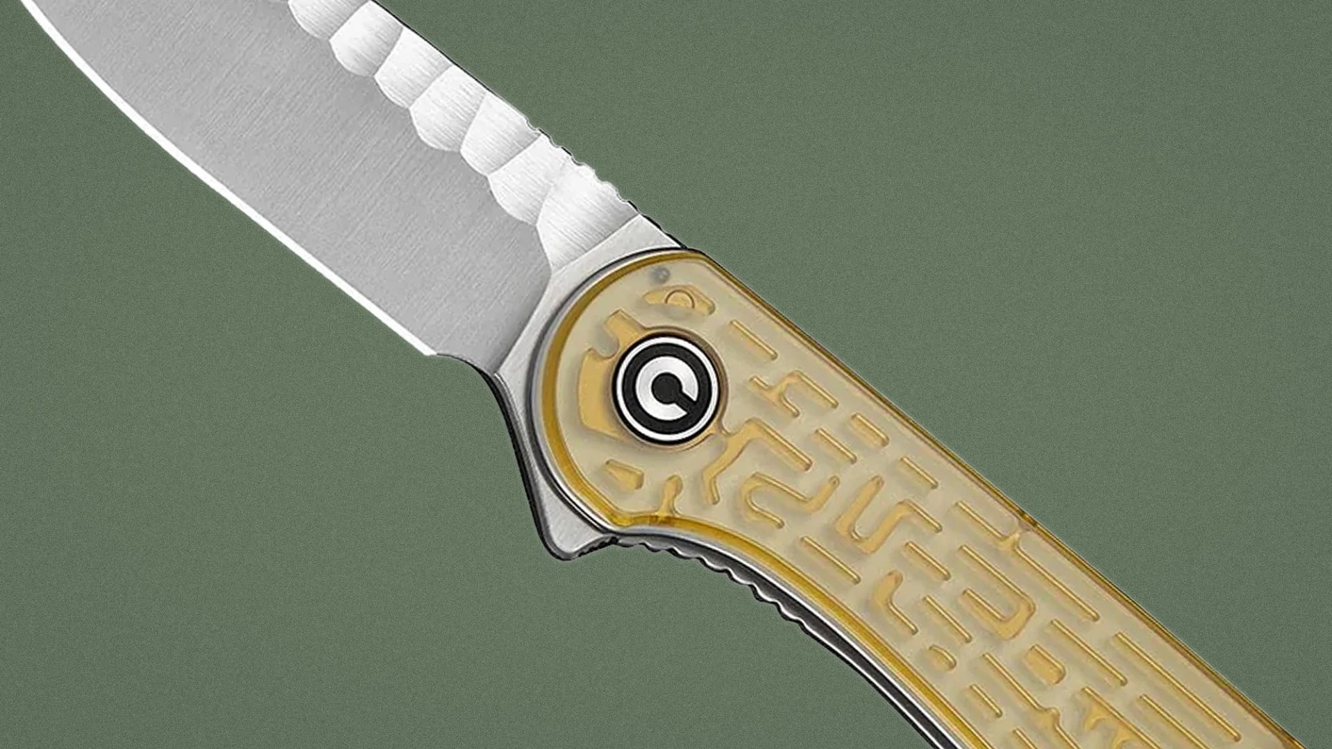 Close-up of a folding knife with a partially serrated stainless steel blade and a translucent yellow handle with a maze pattern.