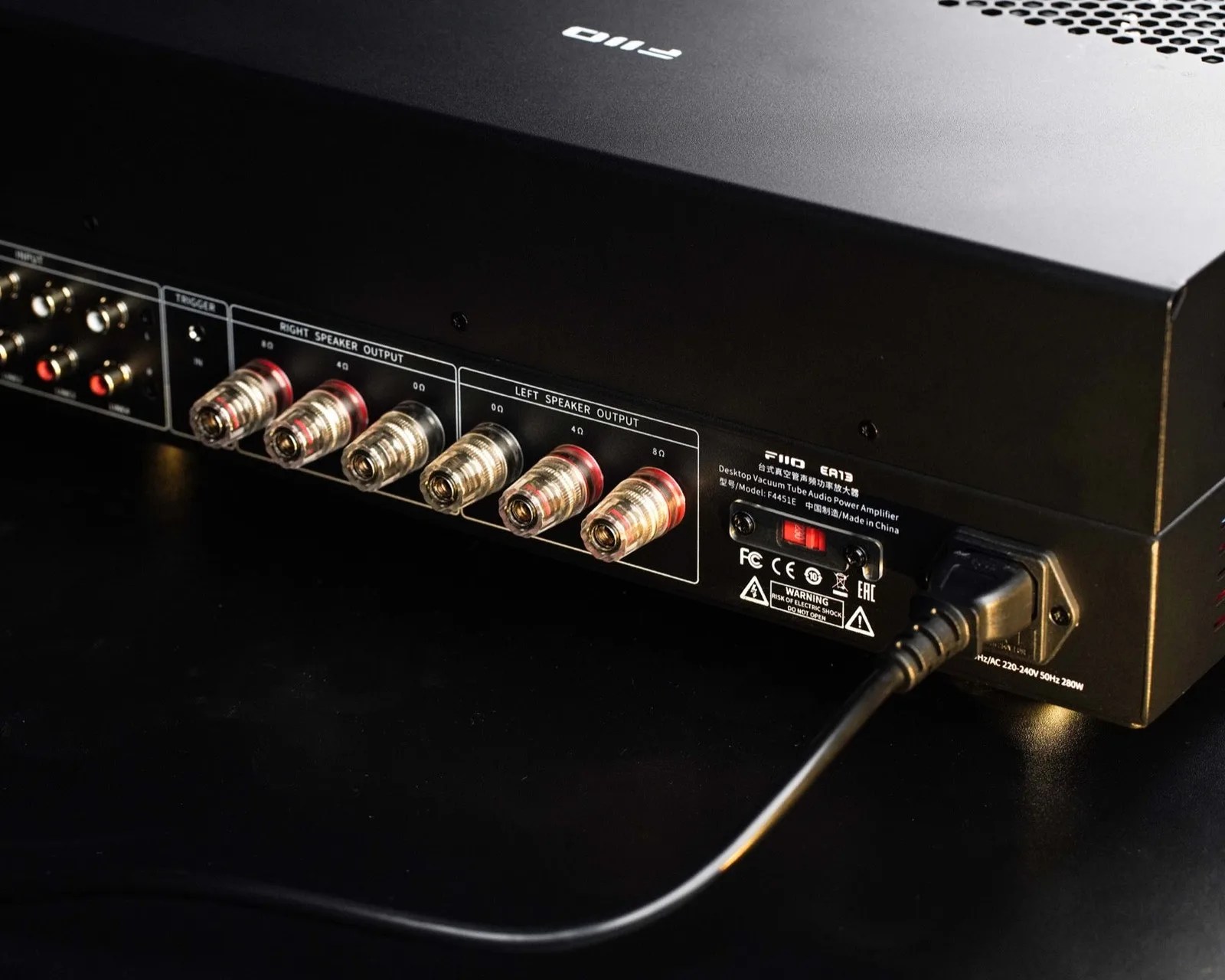 Black FIIO EA13 desktop vacuum tube audio power amplifier showing speaker output terminals and power cable connection.