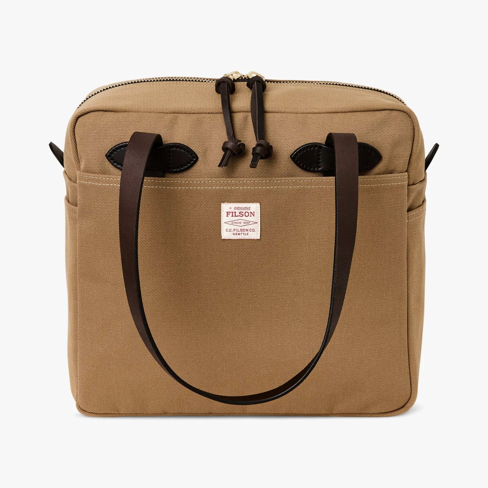 Tan canvas tote bag with dark brown leather handles and a white Filson logo patch on the front.