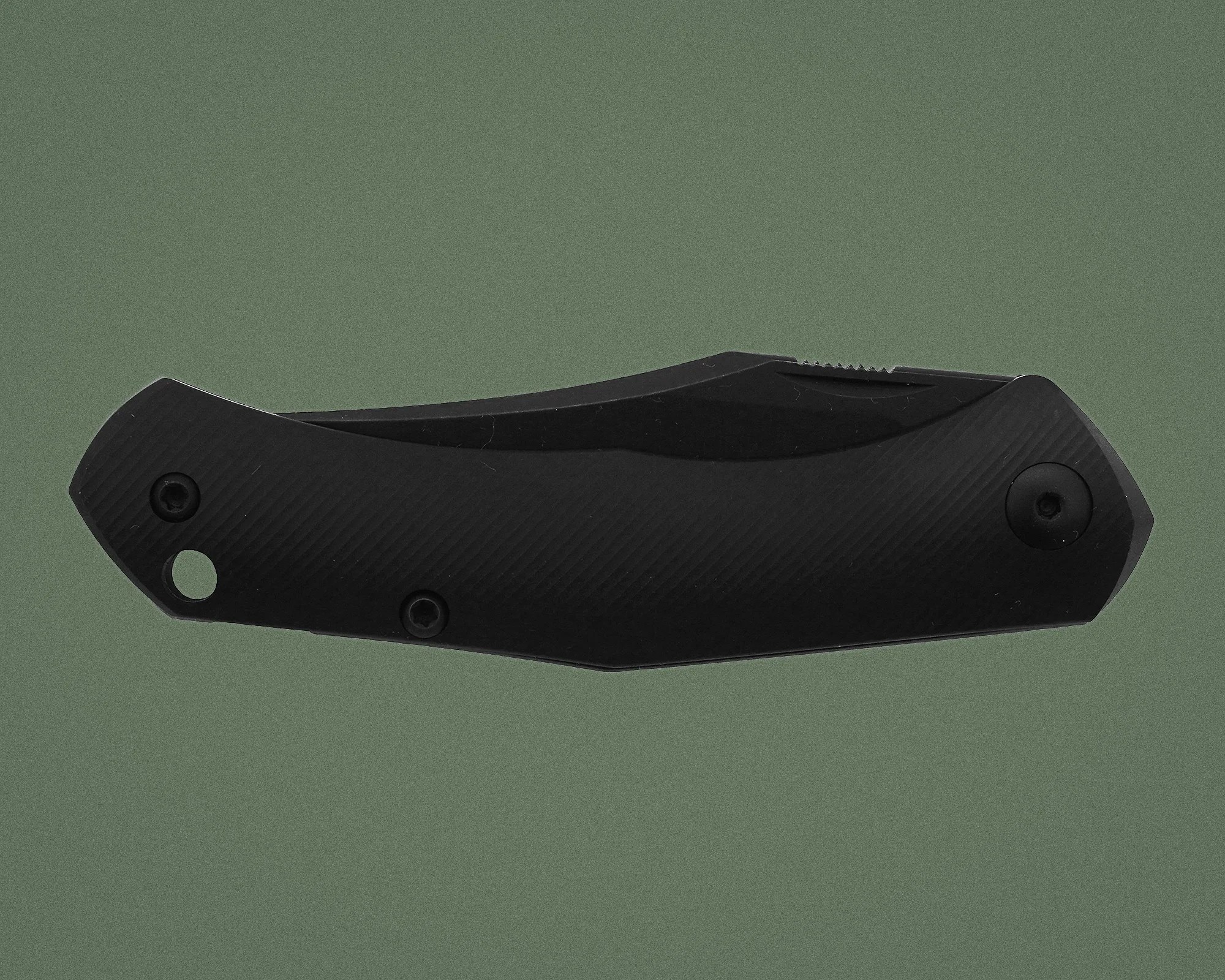 Black folding knife handle with textured grip and visible screws on a green background.