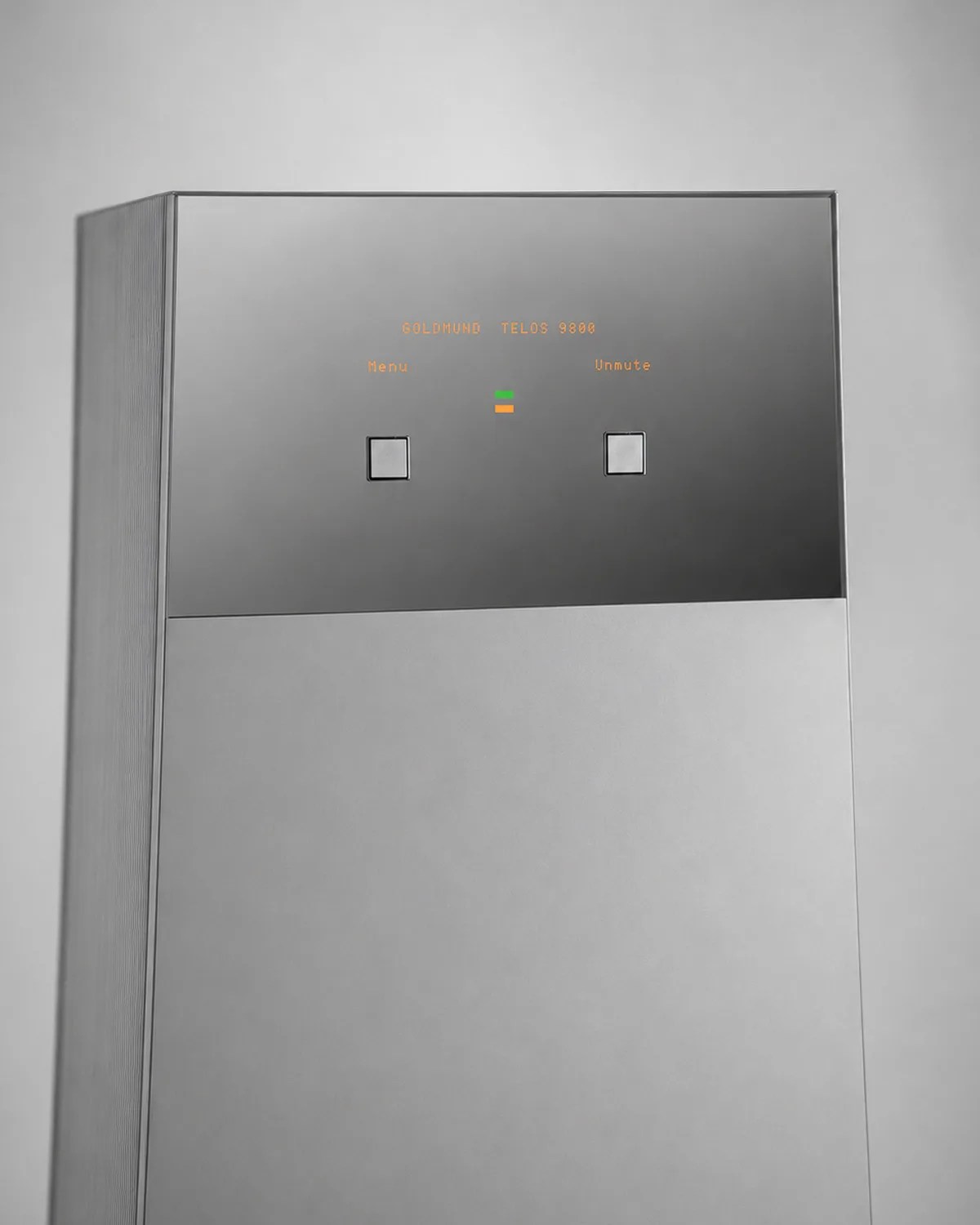 Tall rectangular silver audio equipment with a reflective top panel displaying "Goldmund Telos 9800" and two square buttons.