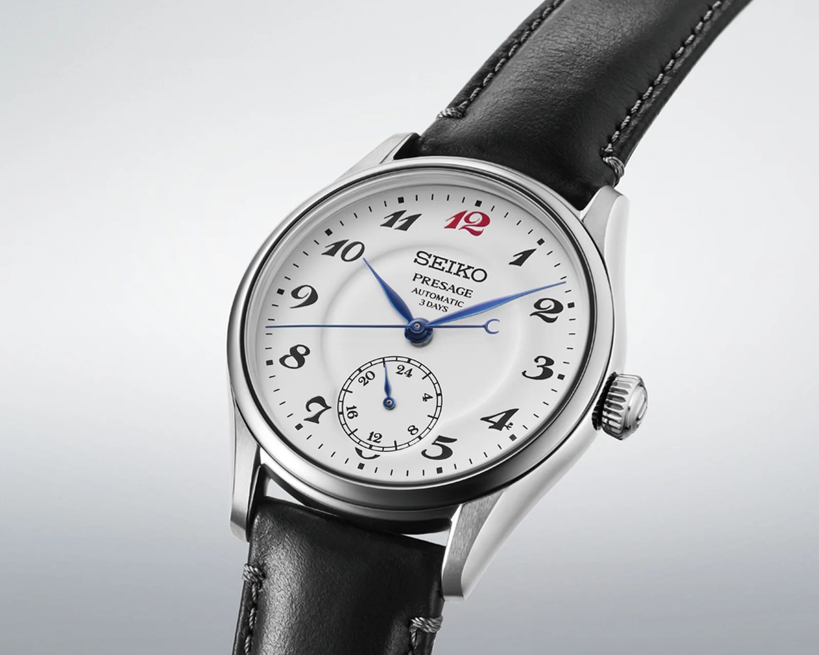 Seiko Presage automatic wristwatch with white dial, black numerals, blue hands, and black leather strap.