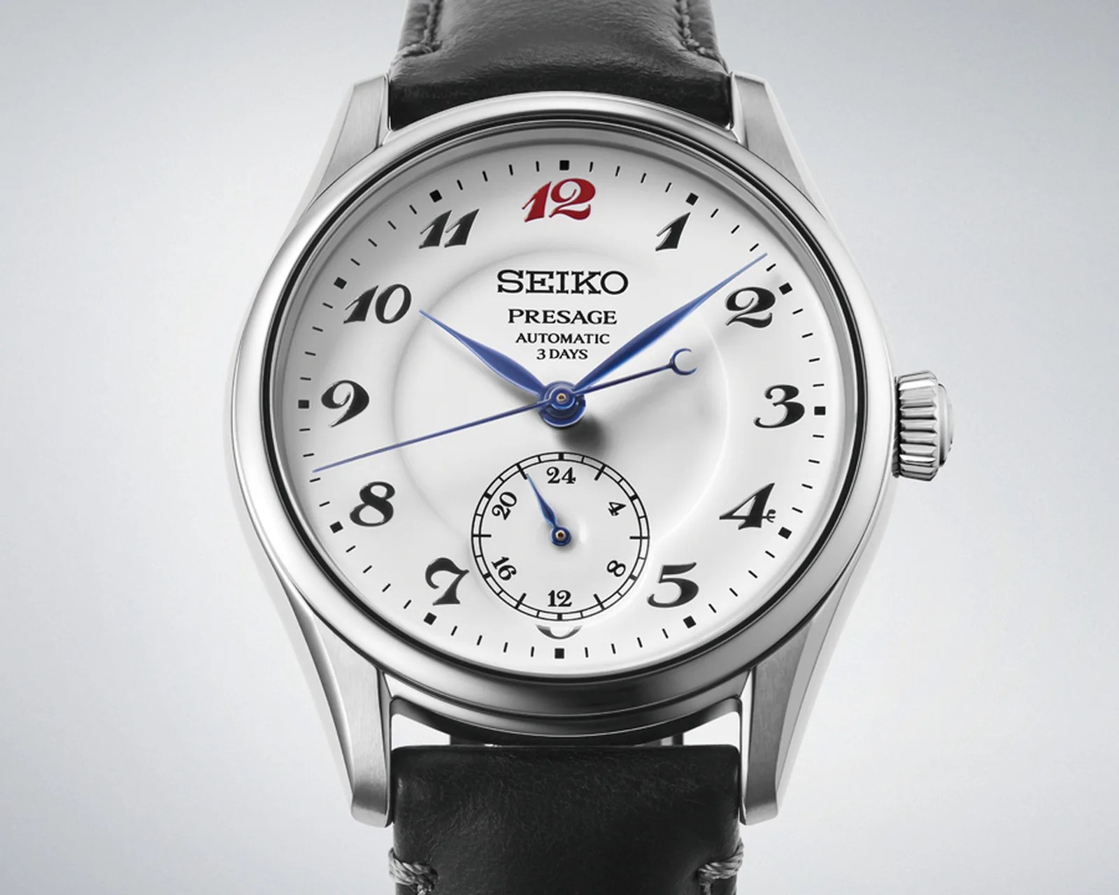 Seiko Presage automatic watch with white dial, black Arabic numerals, blue hands, and black leather strap.