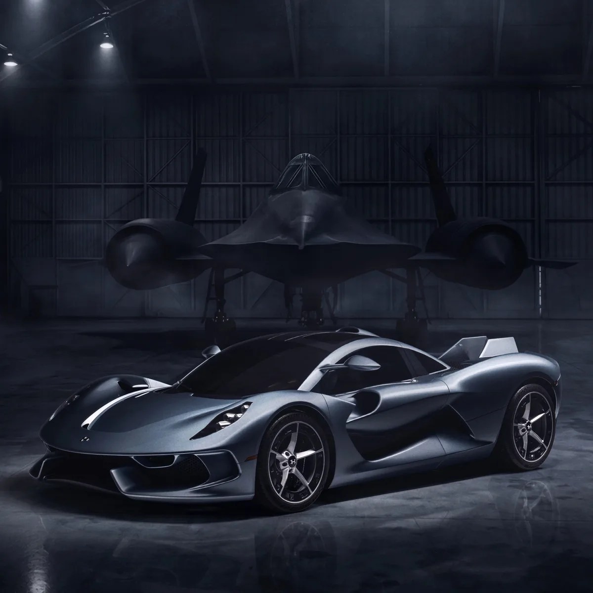 Sleek silver sports car parked inside a dimly lit hangar with a black stealth aircraft in the background.