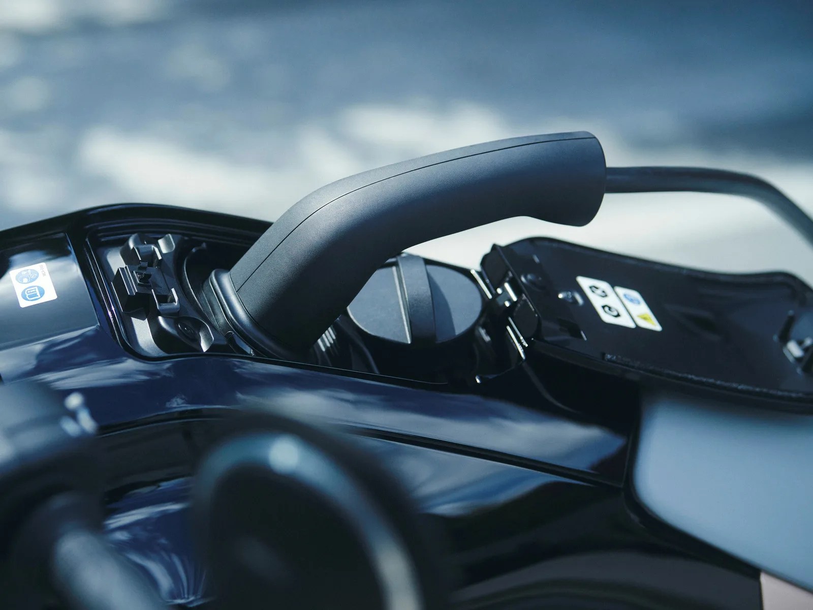 Black electric vehicle charging plug inserted into a glossy black charging port.