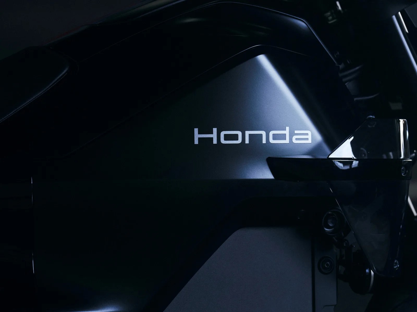 Close-up of a matte black Honda outboard motor with the Honda logo in silver.
