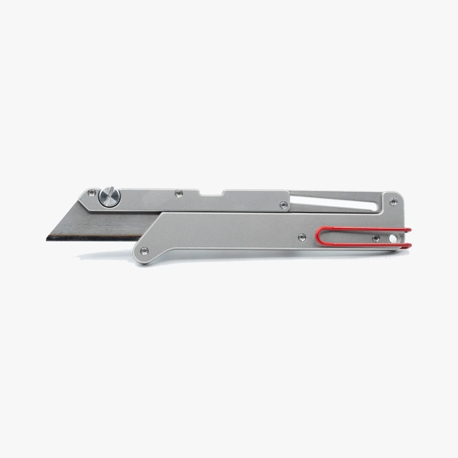 Silver metal utility knife with a red clip on the handle against a white background.