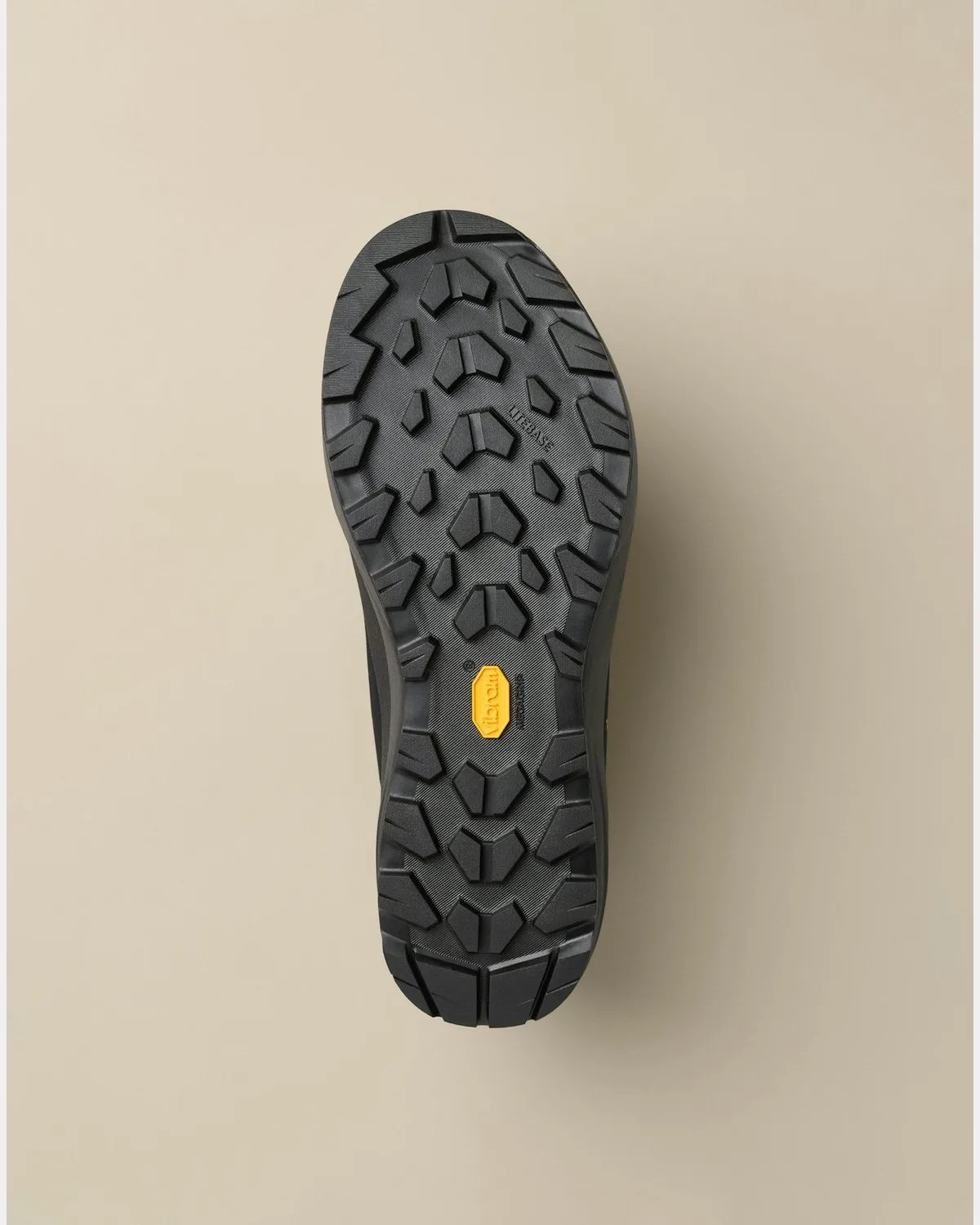 Black Vibram rubber outsole with deep treads and a yellow Vibram logo in the center.