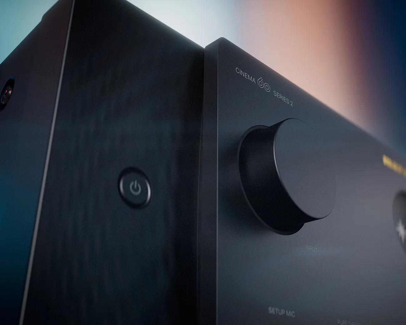 Close-up of a black Cinema 60 Series 2 audio device with a large knob and power button.