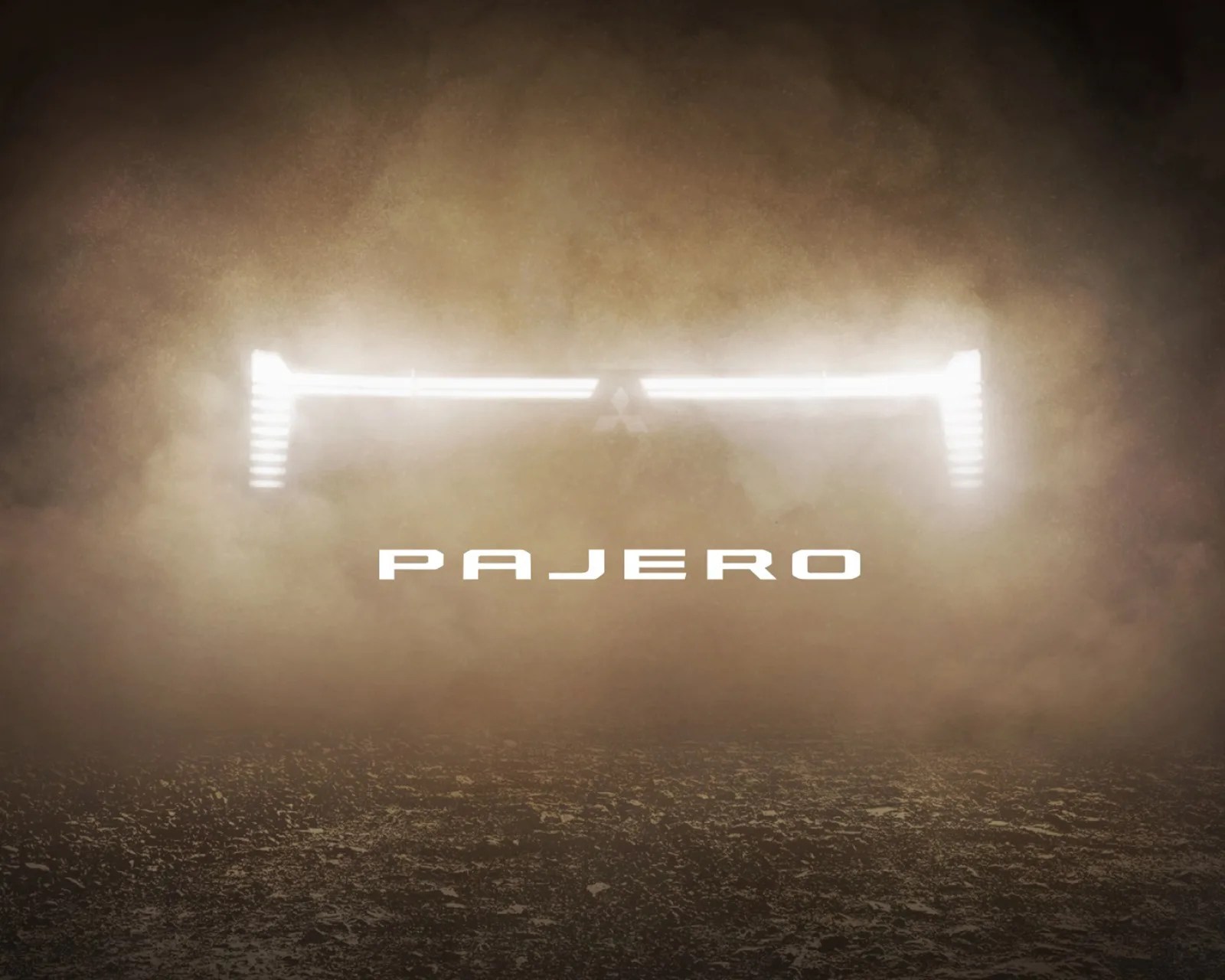 Bright horizontal LED light bar with vertical end lights and "PAJERO" text below in dusty environment.