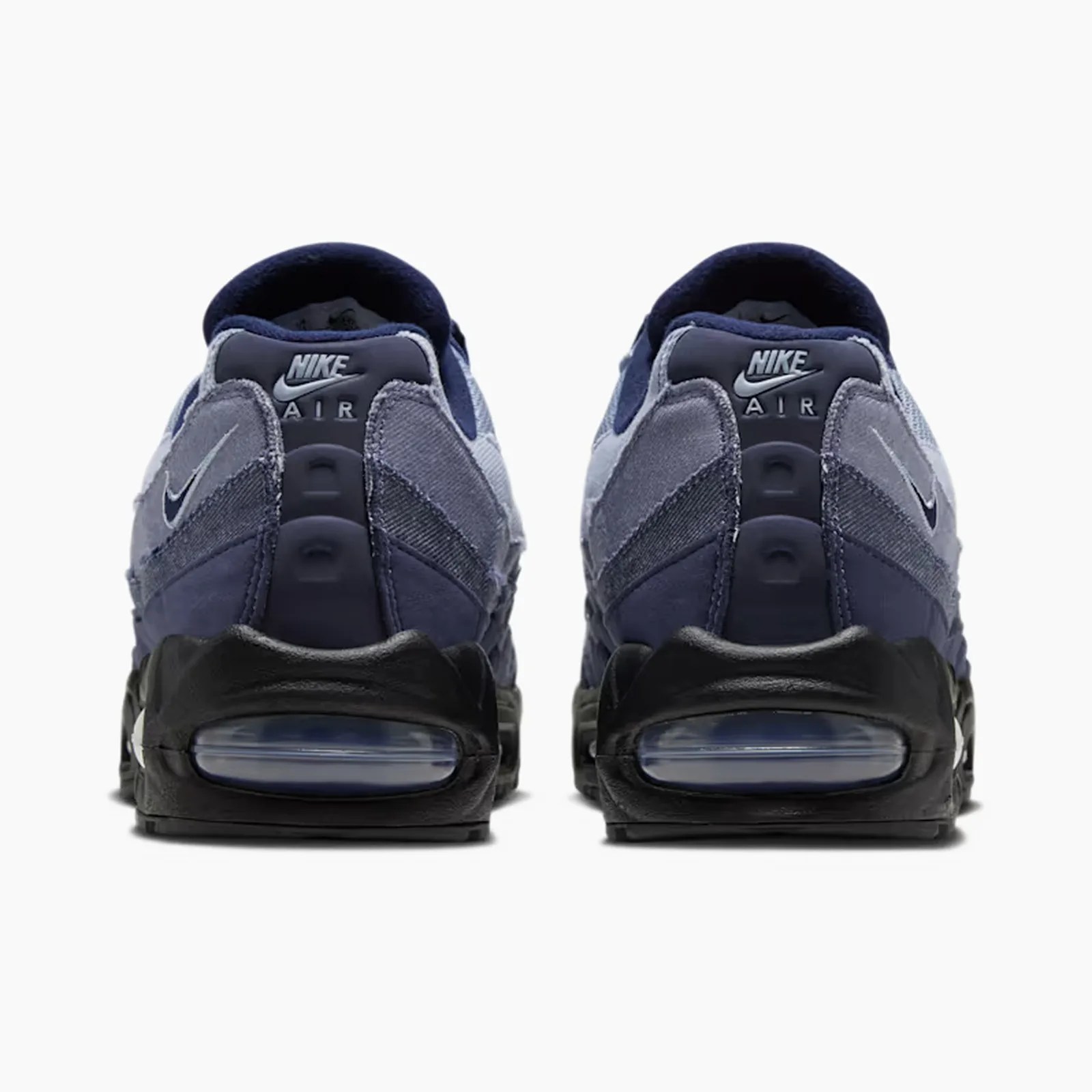 Pair of navy and gray Nike Air sneakers shown from the back with visible air cushioning in black soles.