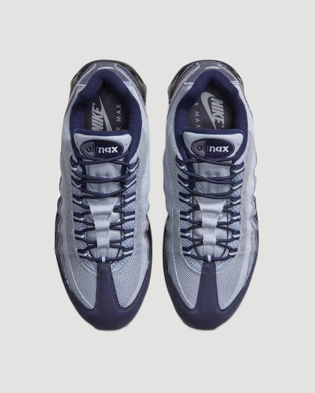 Pair of gray and navy Nike Air Max sneakers viewed from above on a light gray background.