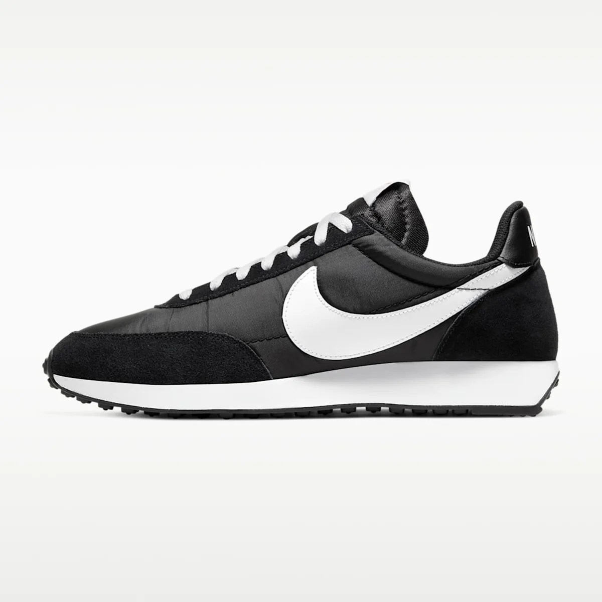 Black and white Nike sneaker with white swoosh logo and white laces, side view.