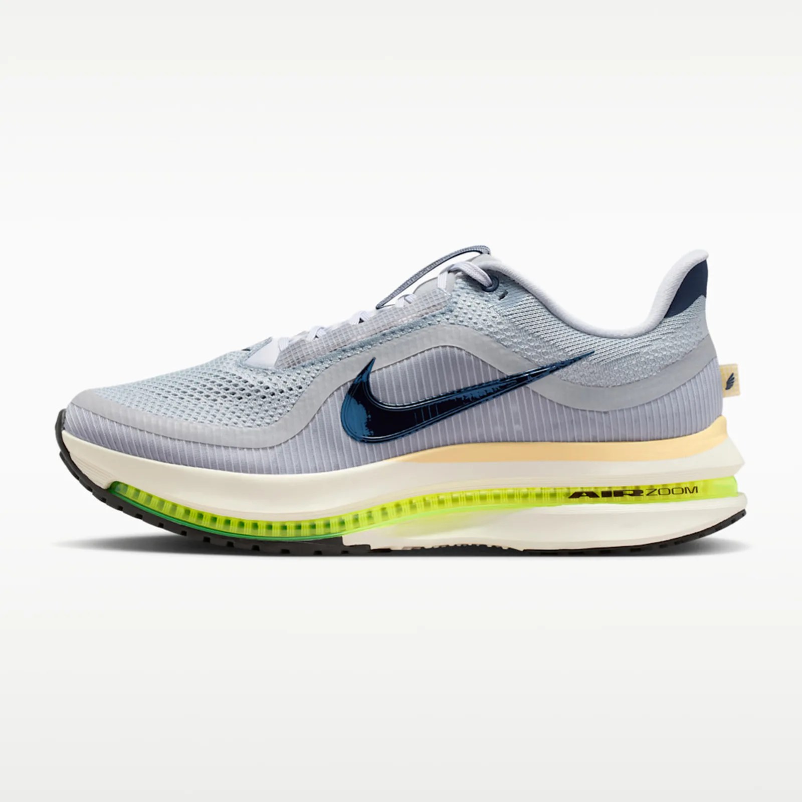 Light gray Nike Air Zoom sneaker with dark blue swoosh and neon yellow air cushion sole.