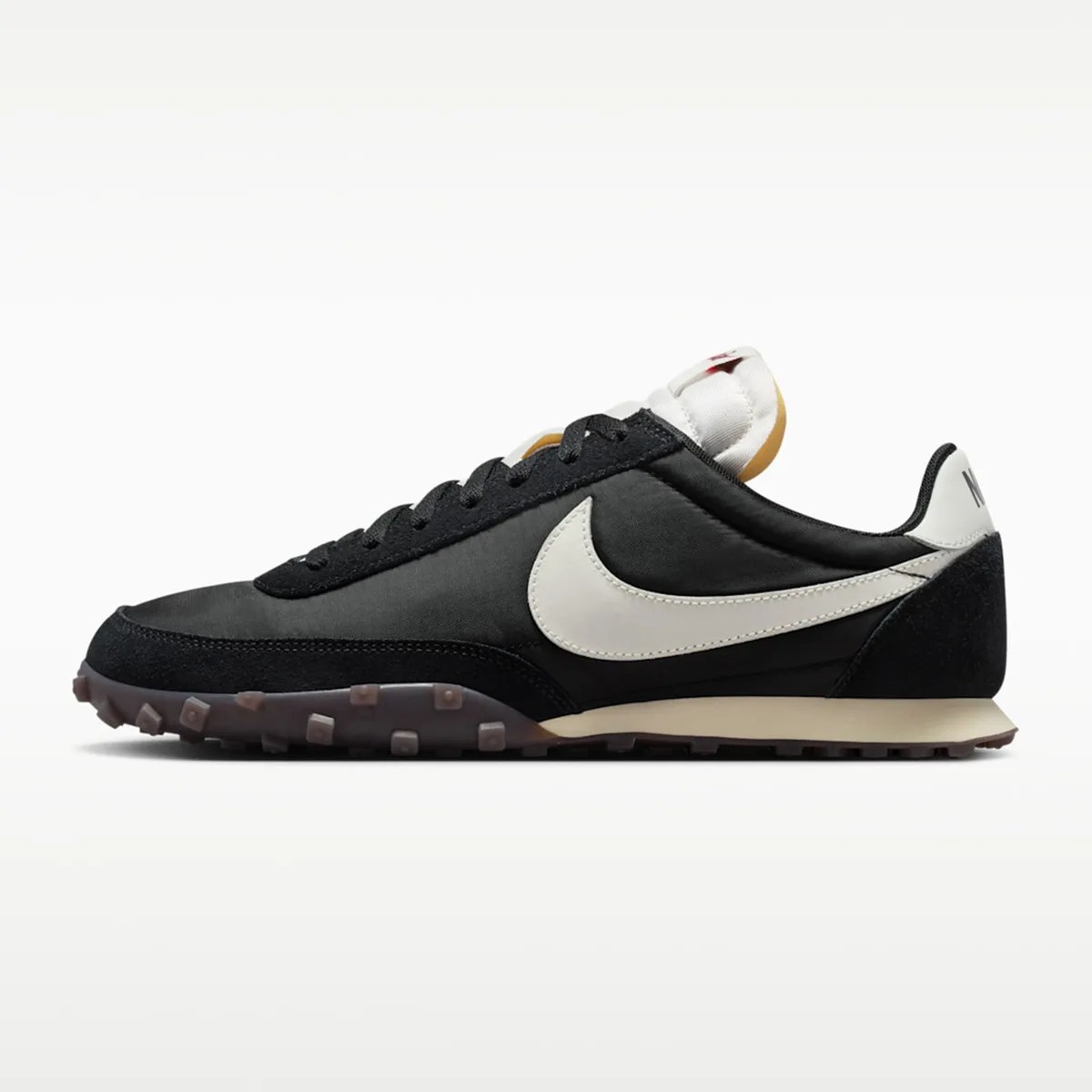 Black and white Nike sneaker with a white swoosh and textured brown sole, side view.