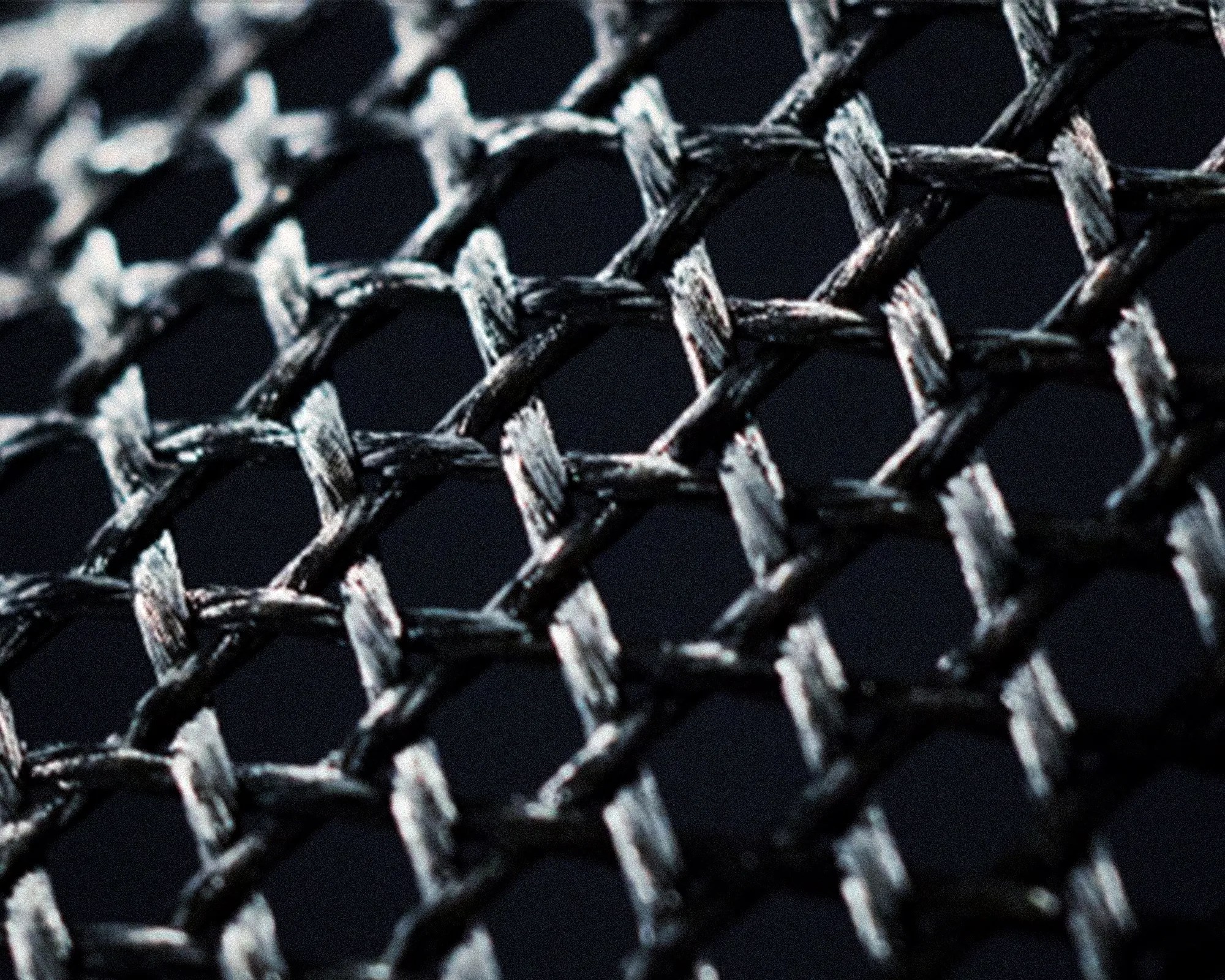 Close-up of black and white woven fabric with a diamond pattern on a dark background.