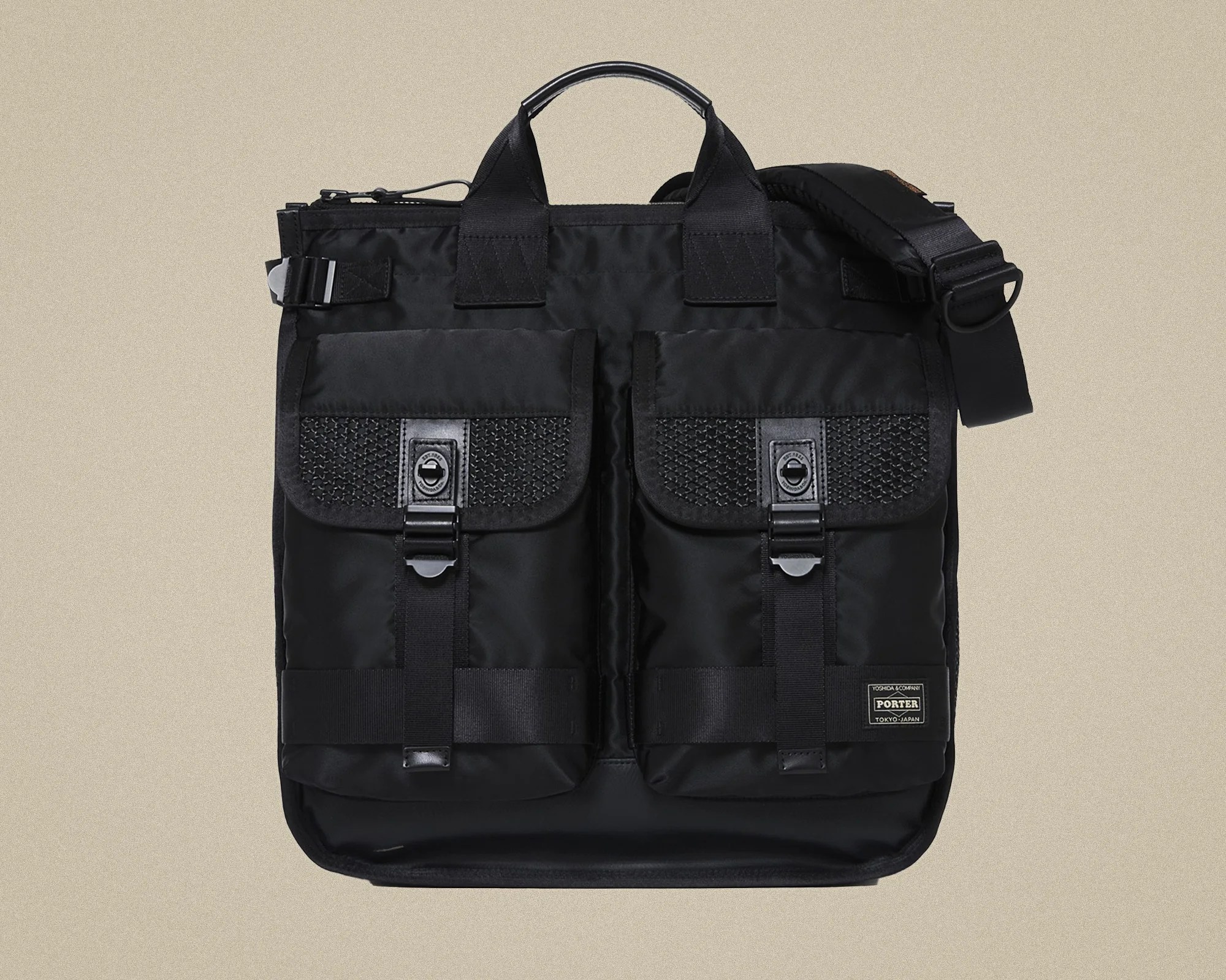 Black nylon messenger bag with two front flap pockets featuring mesh details and metal clasps.