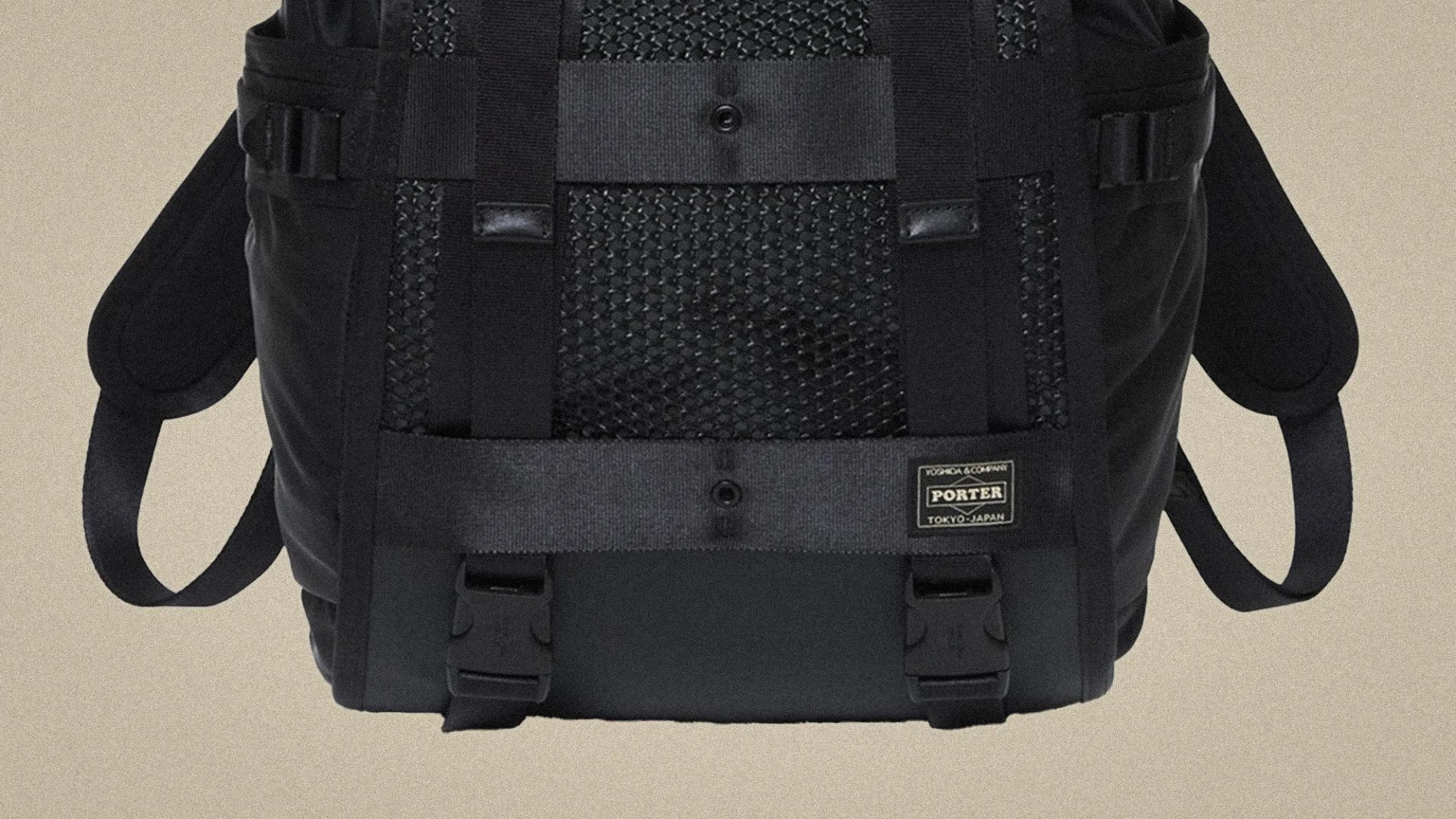 Black Porter backpack with mesh panel, adjustable straps, and front buckle closures on a beige background.