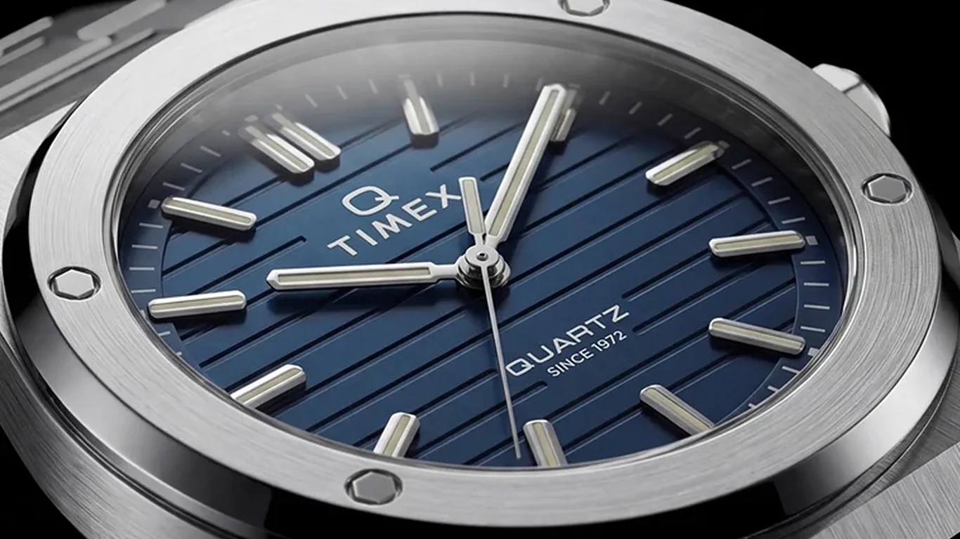 Close-up of a Timex quartz watch with a blue striped dial and silver hour markers and hands.